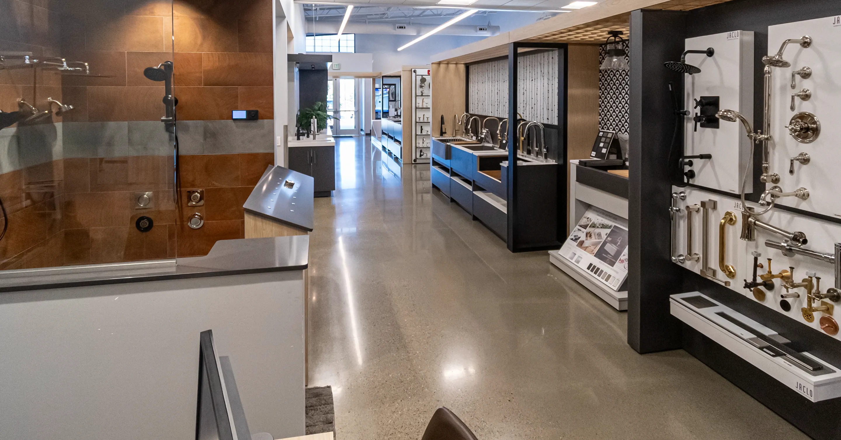 Bathroom fixture displays at The Water Closet showroom, showcasing showerheads, faucets, and sinks.