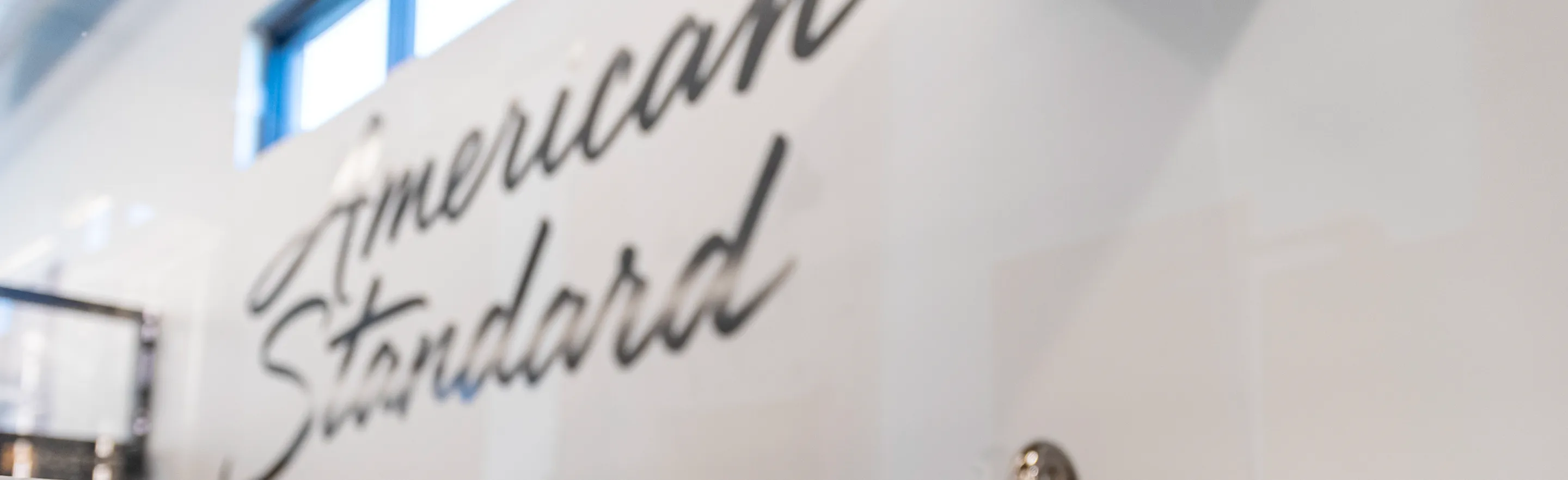 Close-up of the American Standard logo displayed inside The Water Closet showroom in Billings, Montana.