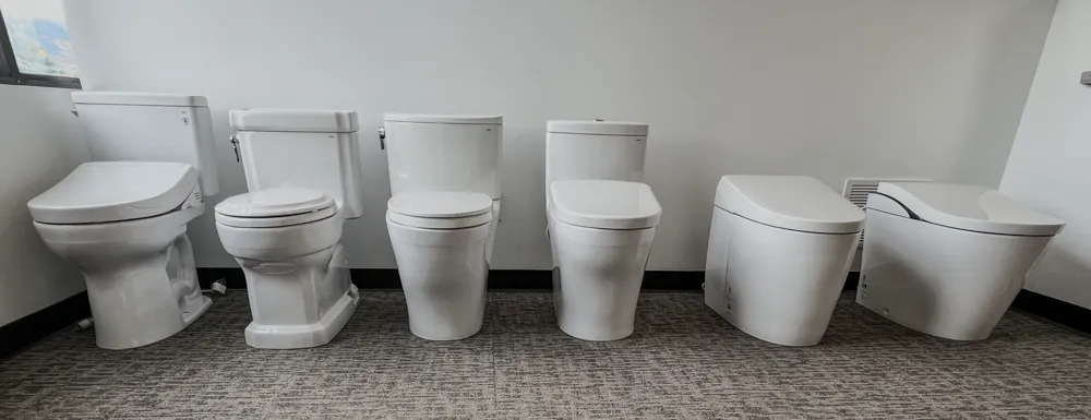Row of toilet displays along showroom wall in Bozeman location
