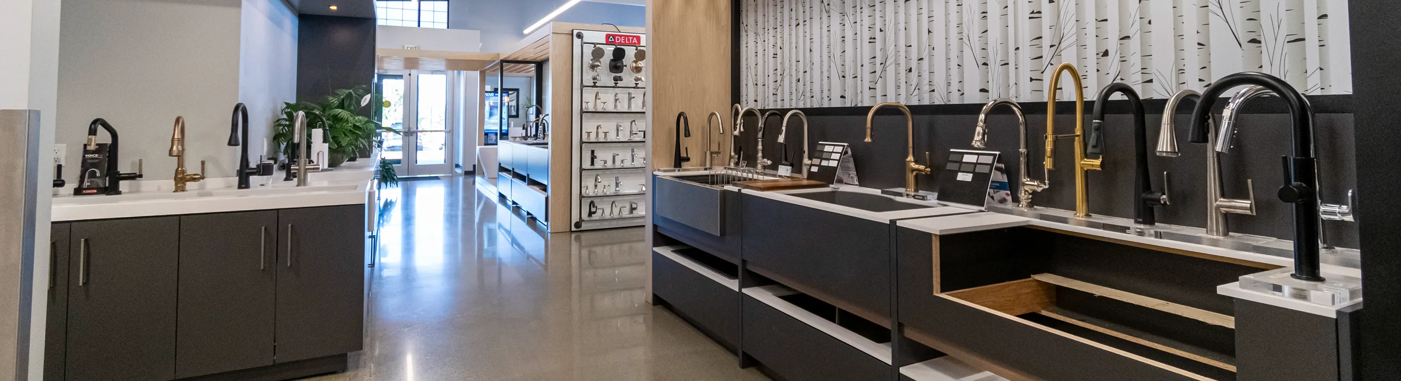 Spacious showroom at The Water Closet with rows of kitchen sink and faucet displays under bright lighting.