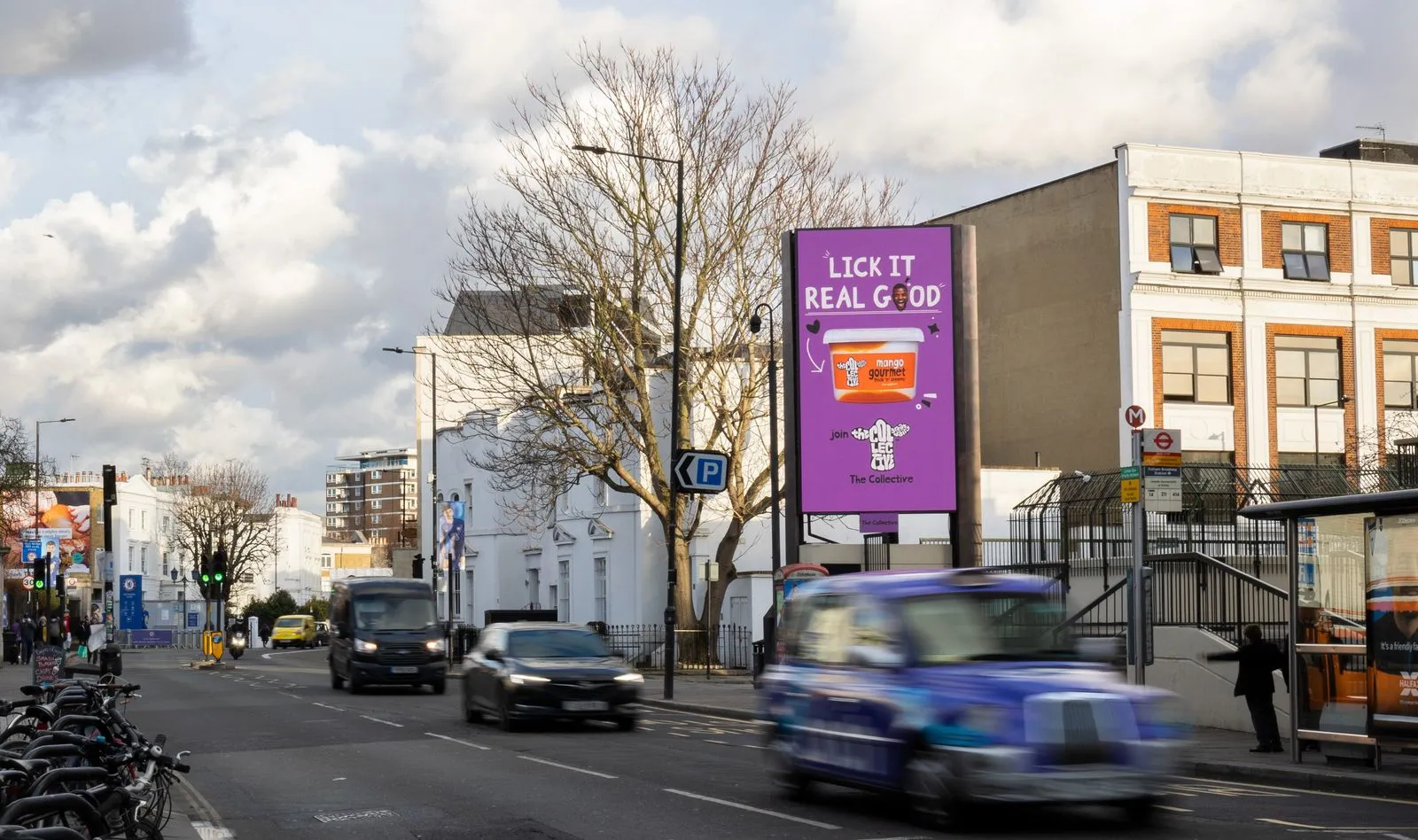 The Collective's purple 'Lick it real good' yoghurt advertisement on Storm Fulham Broadway with lots of traffic