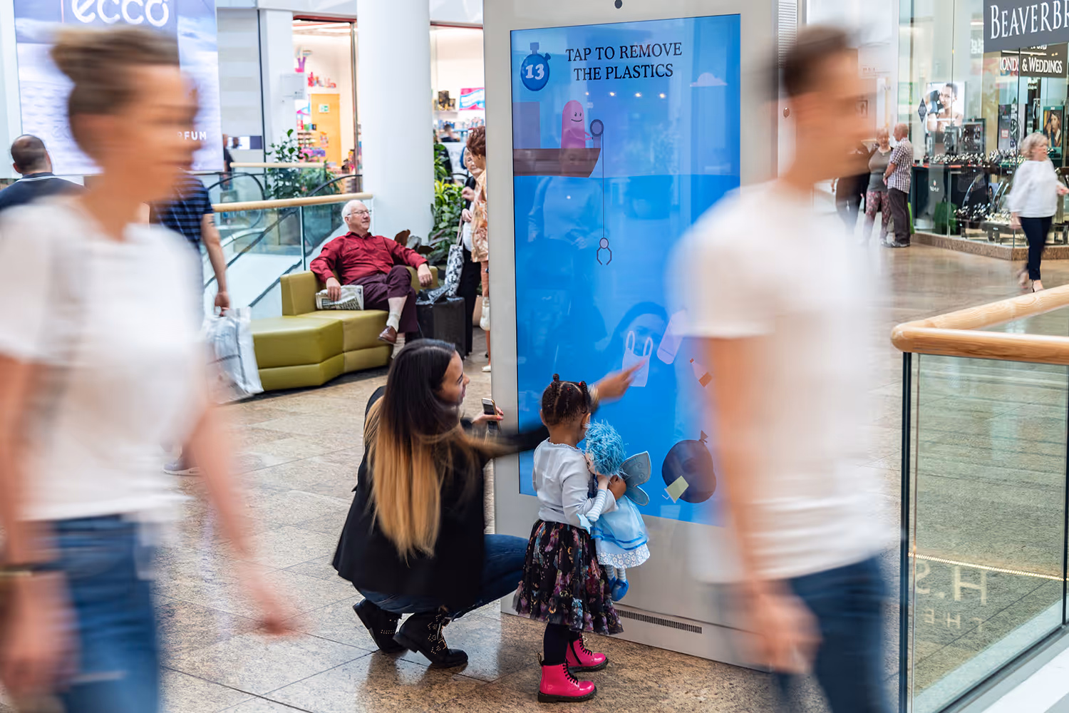 A family play on an interactive digital screen in a shopping mall
