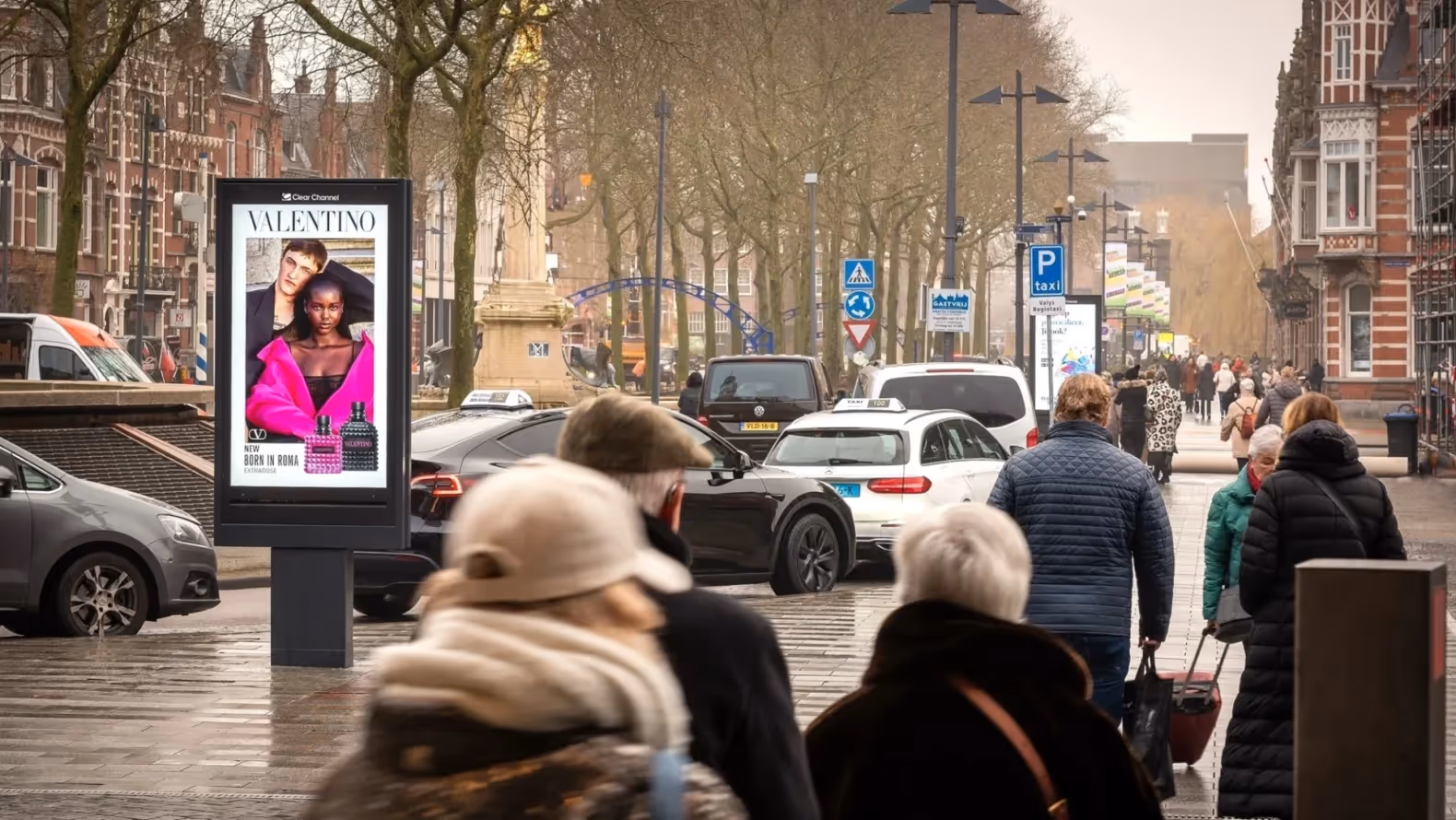 Valentino reclame op digitaal scherm met voorbijgangers