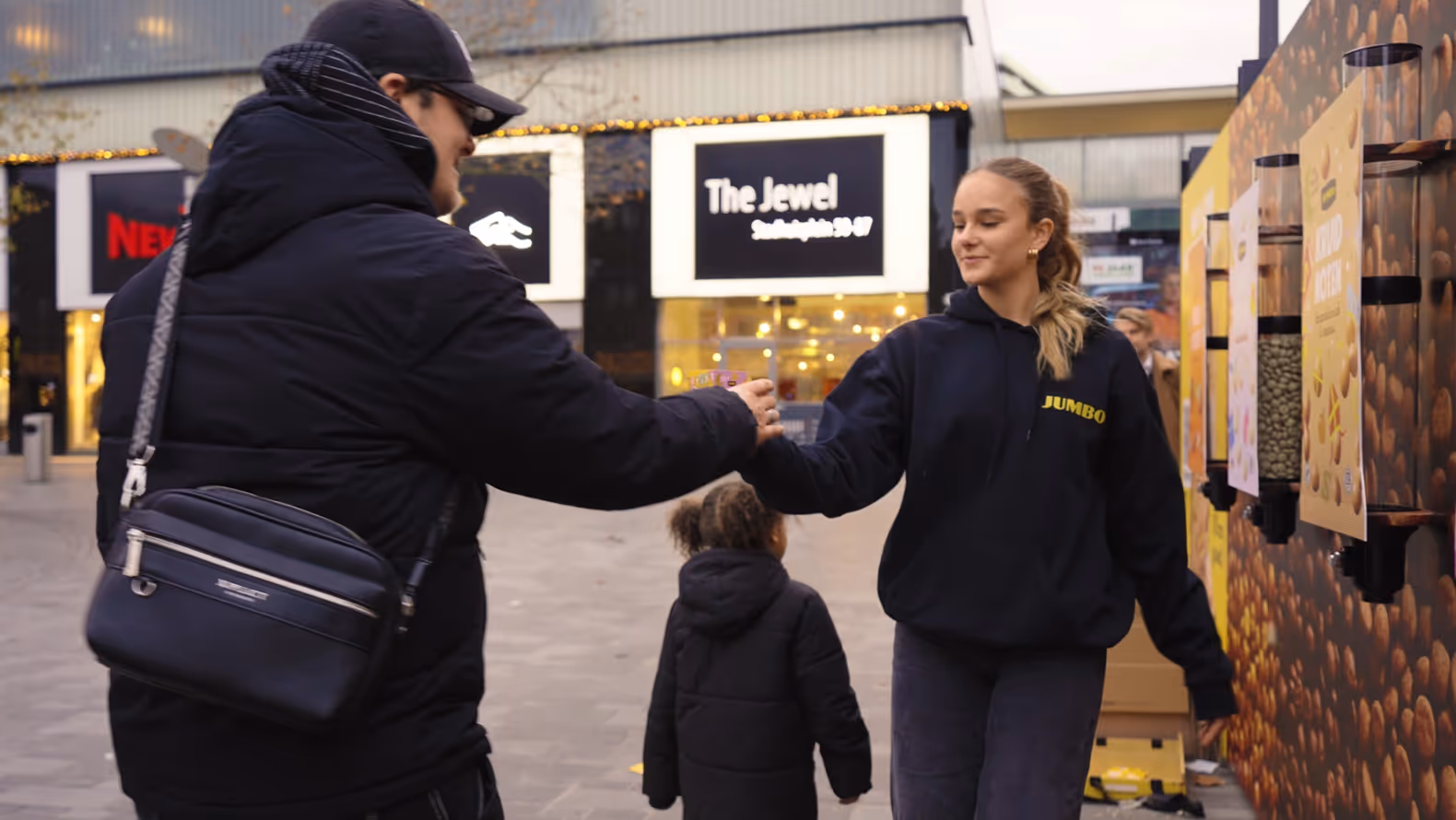Man krijgt pepernoten van vrouw bij bushalte