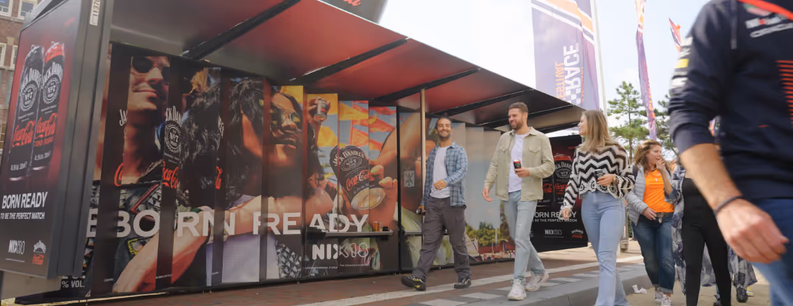 Bushalte met full wrap en voetgangers die voorbij lopen