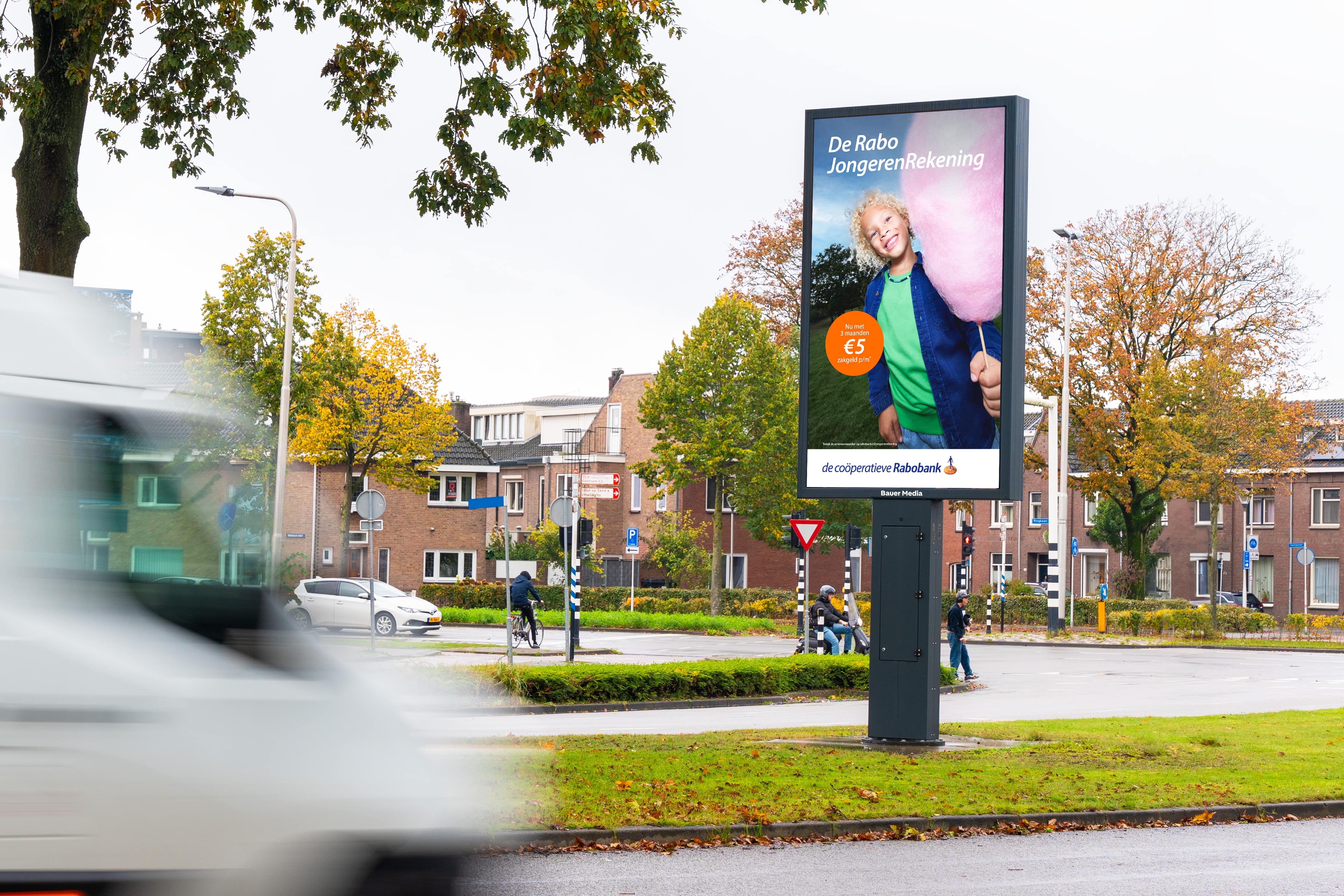 Groot reclameobject langs weg met voorbij rijdende auto