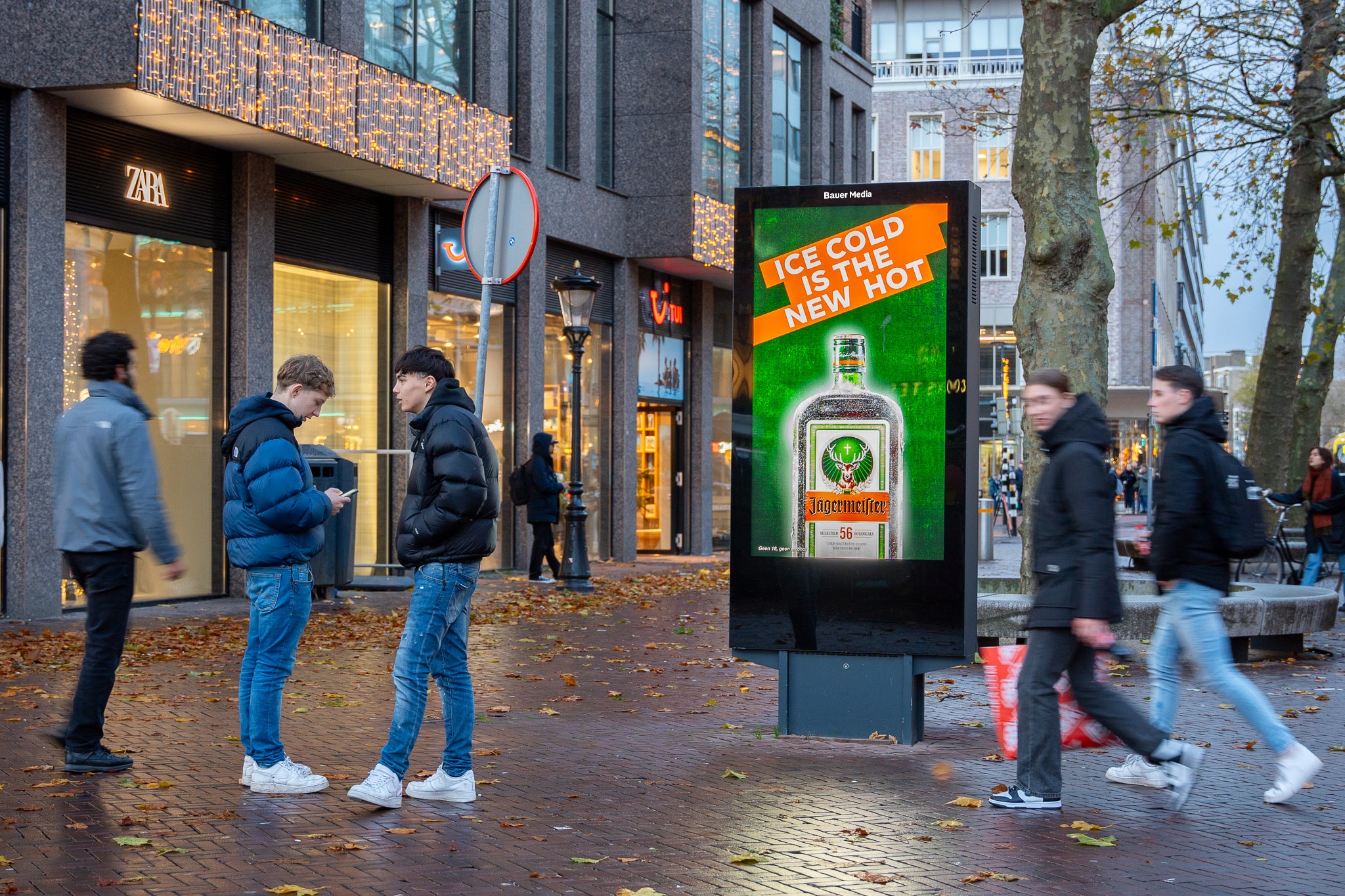 Digitaal scherm met Jagermeister reclame op plein met voorbijgangers