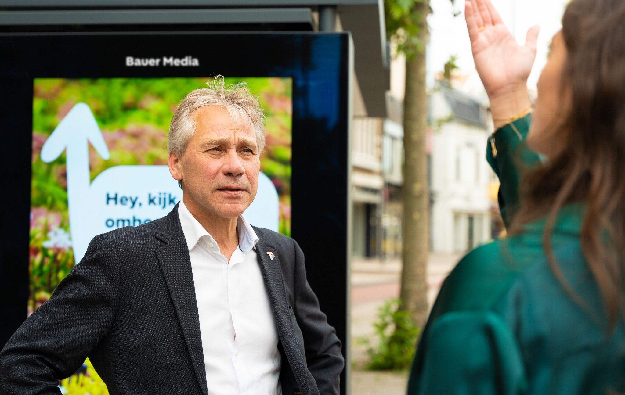 Man en vrouw praten met elkaar voor bushalte