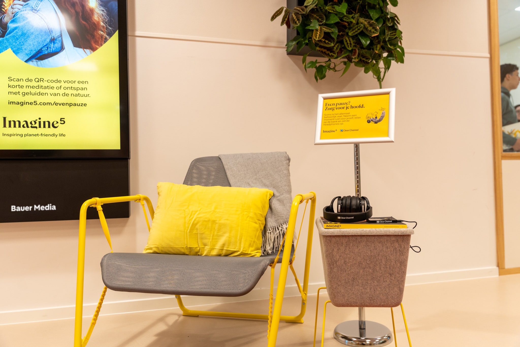 Stoel en tafel met daarop een koptelefoon naast digitaal scherm met