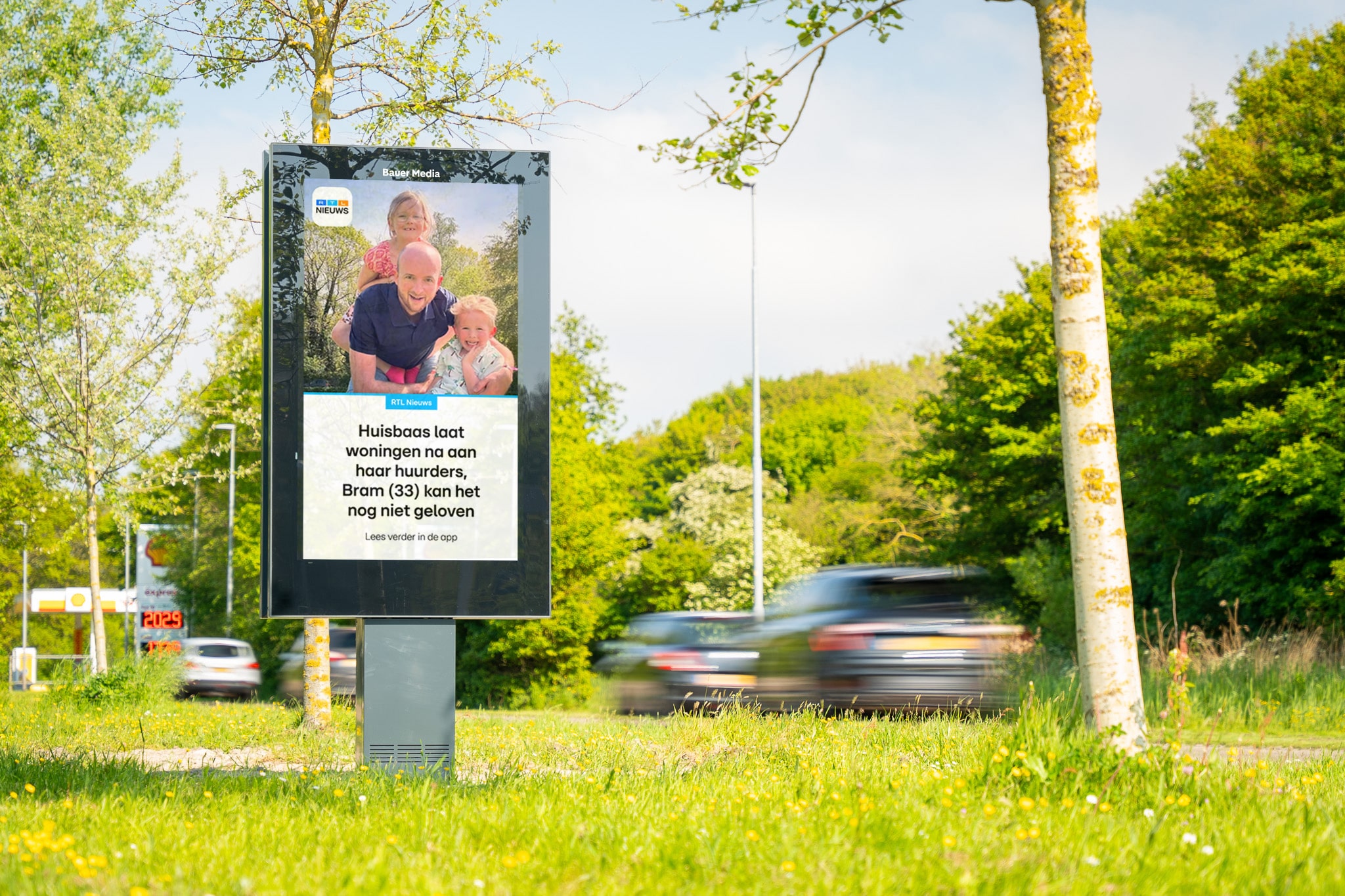 Digitaal scherm langs drukke weg met voorbijrijdende auto's