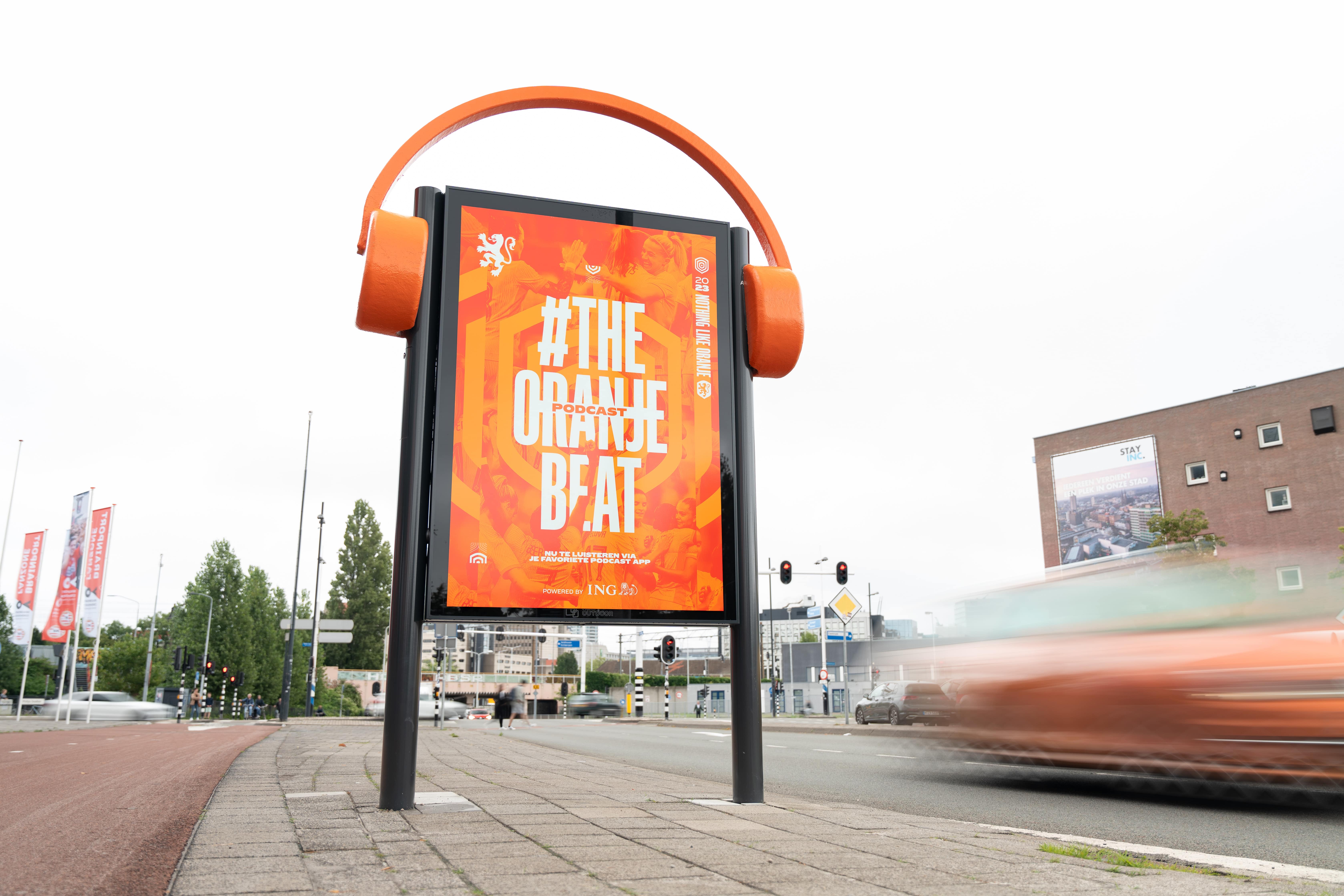 Reclameobject langs weg met Oranje reclame en grote koptelefoon op object