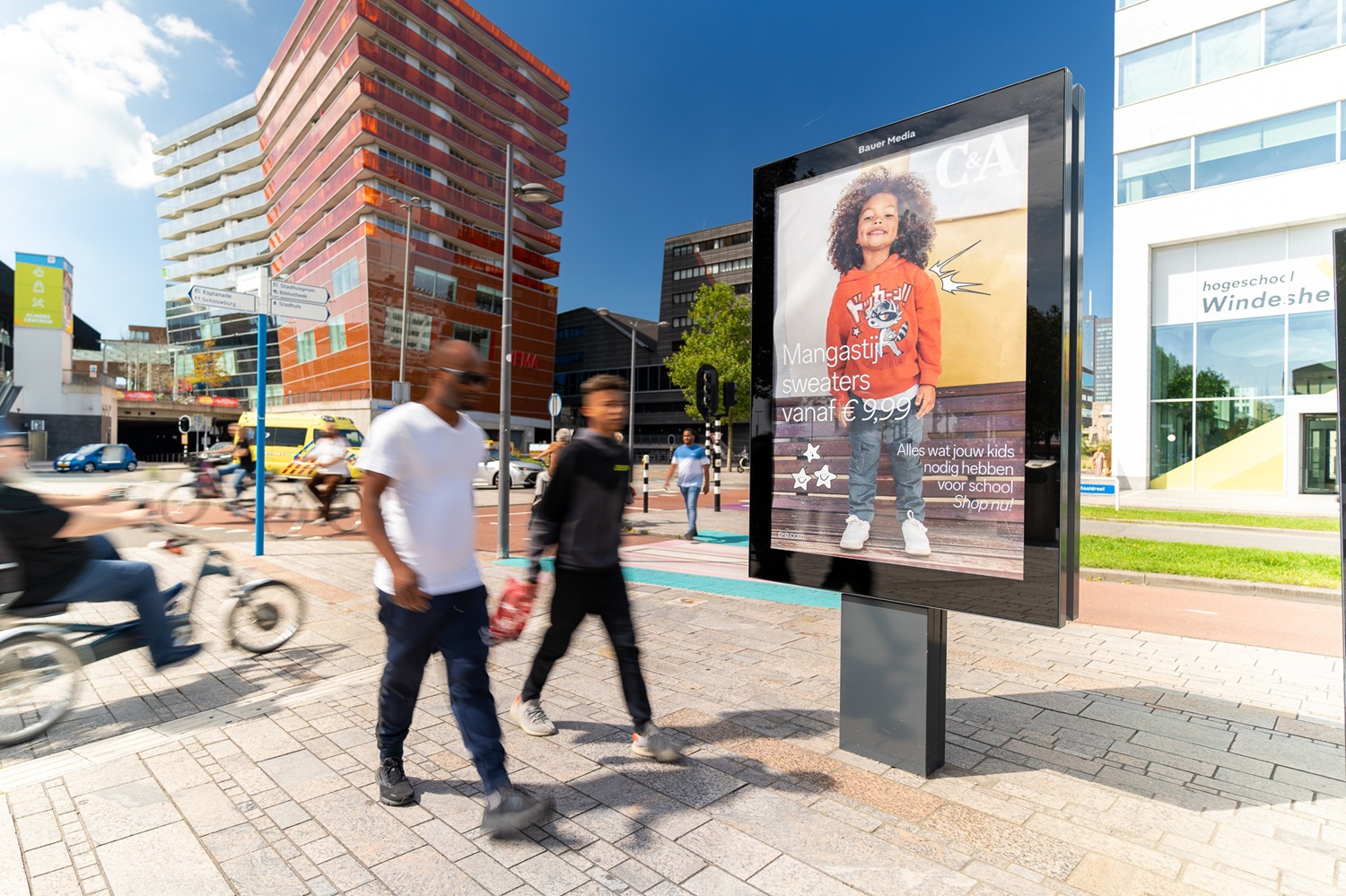 Vrijstaand reclameobject en 2 mannen lopen voorbij