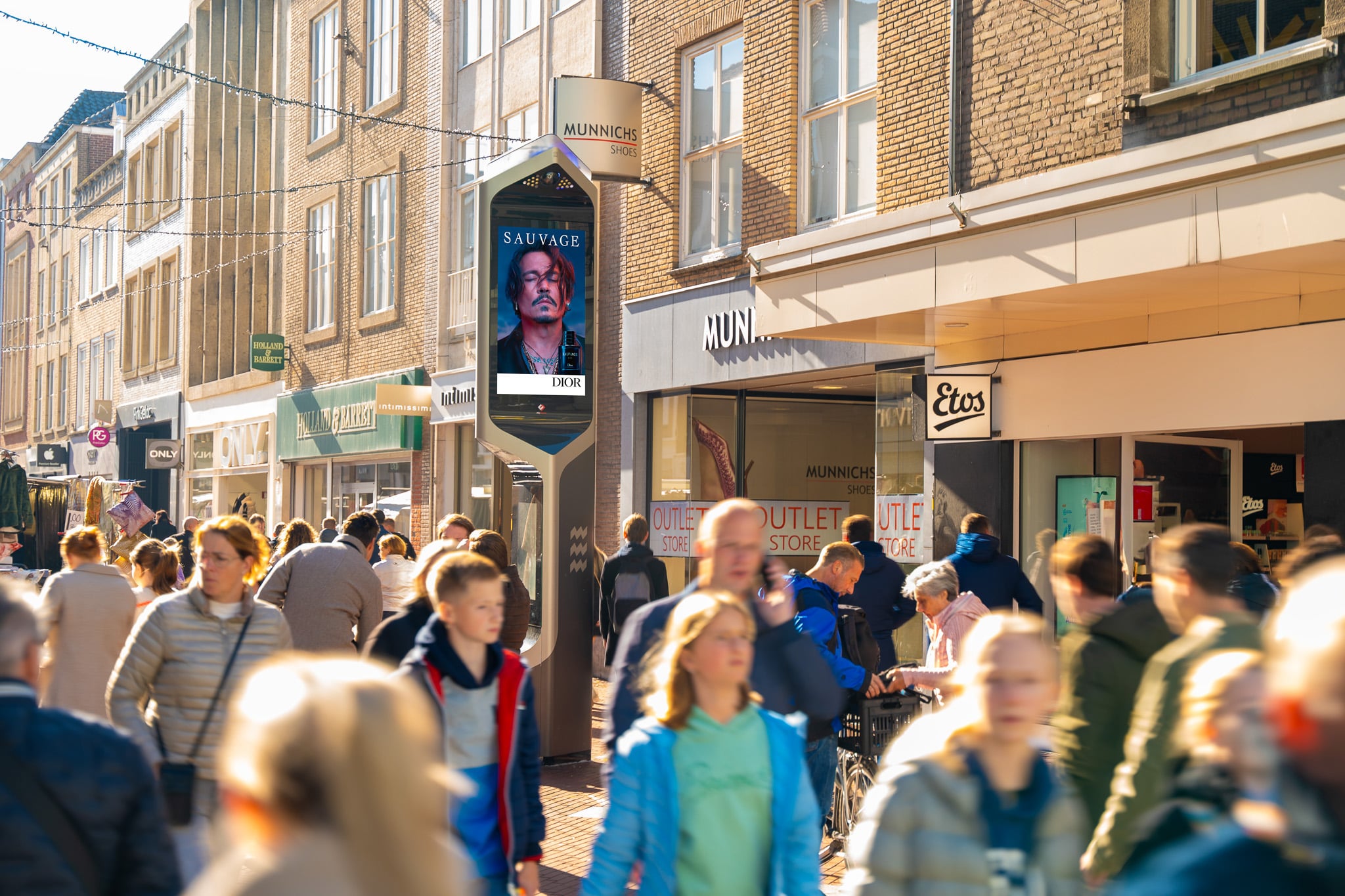 Digitaal scherm in Eindhoven, midden in winkelstraat met winkelend publiek