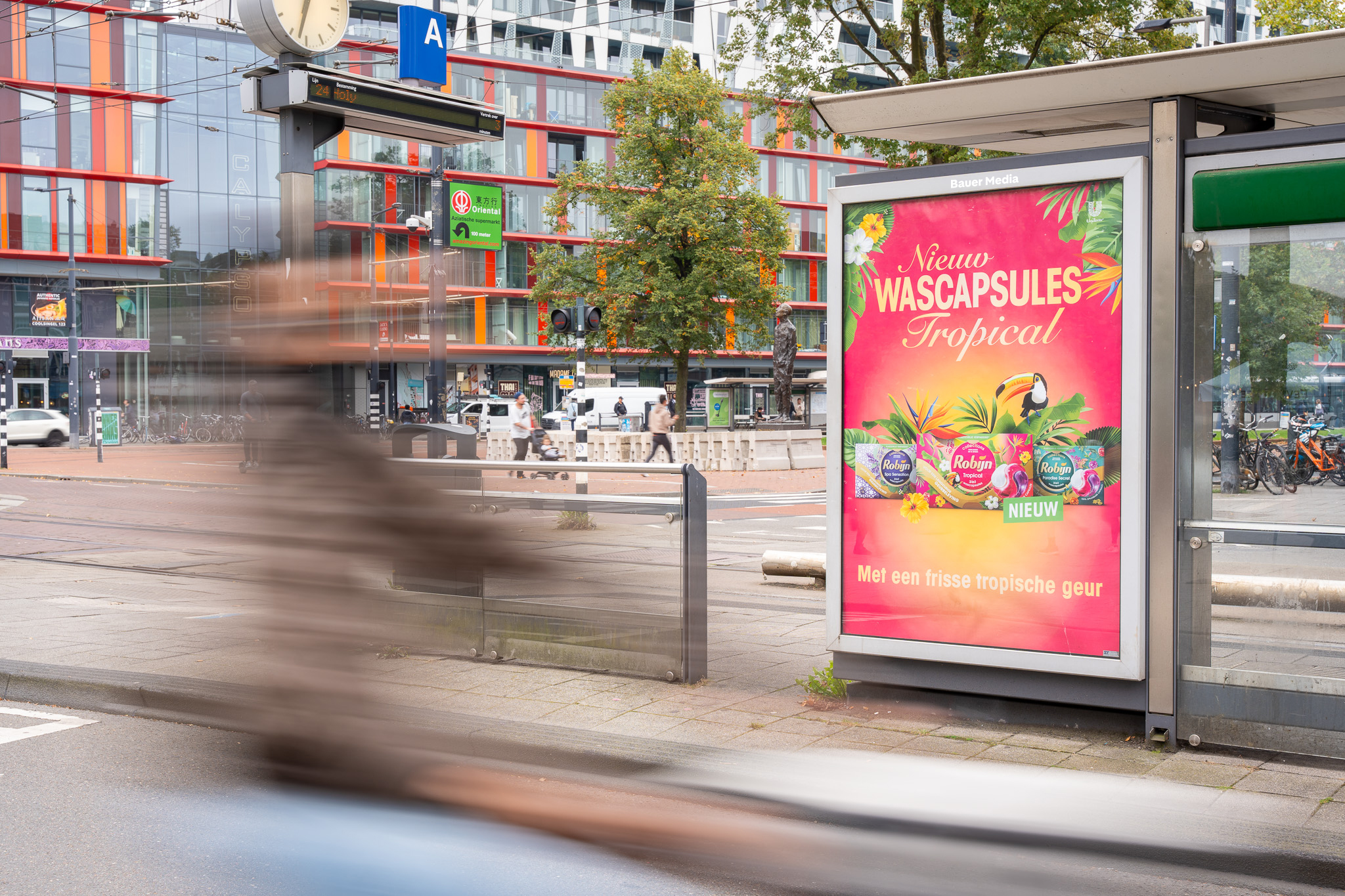 Robijn reclame in bushalte Rotterdam met voorbijgaande fietser