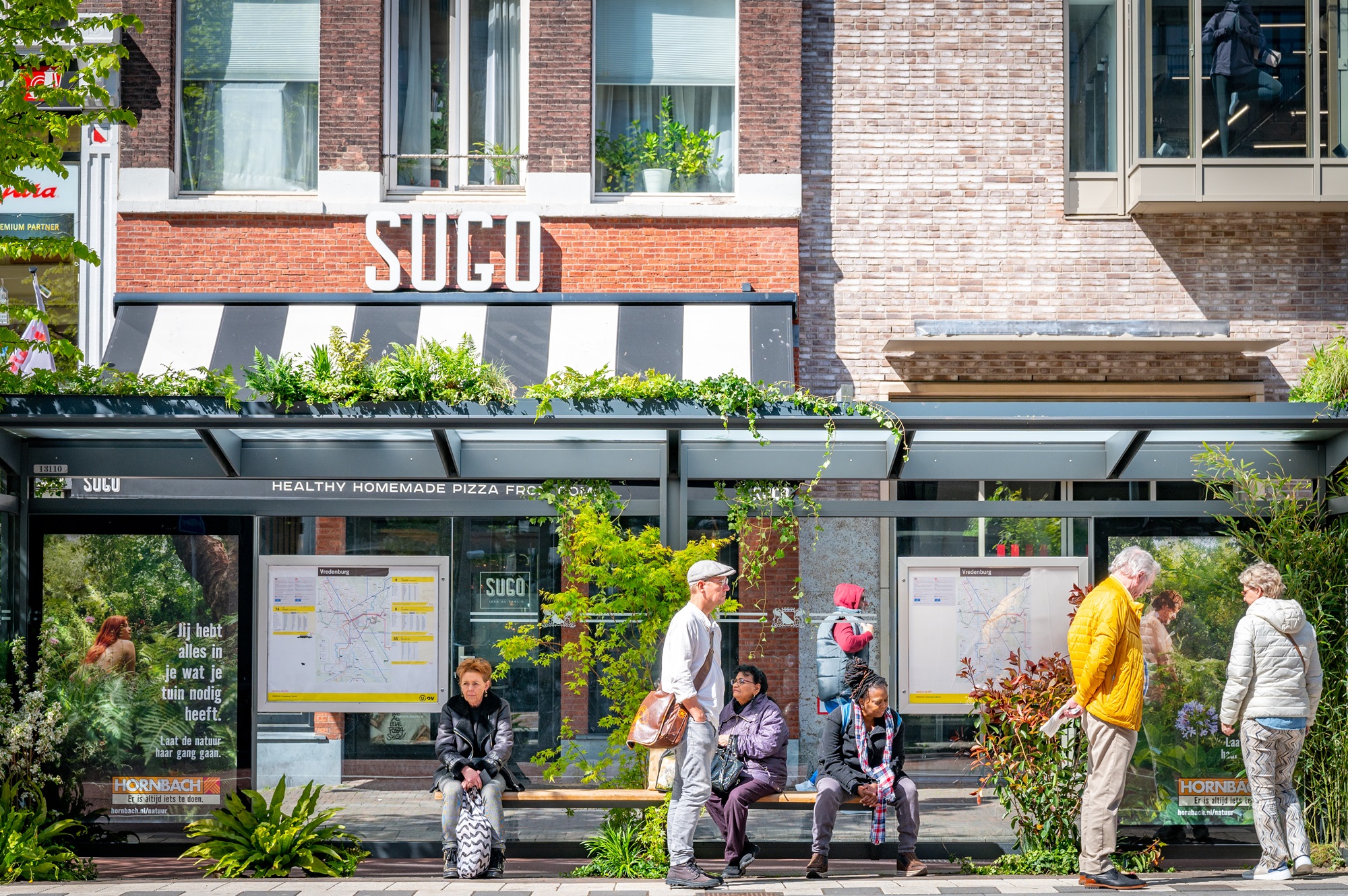 Bushalte met Hornbach reclame en voorbijgangers