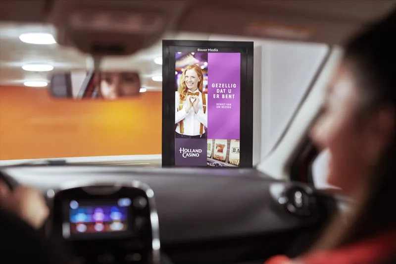 Vanuit de auto zien we een digitaal reclame scherm