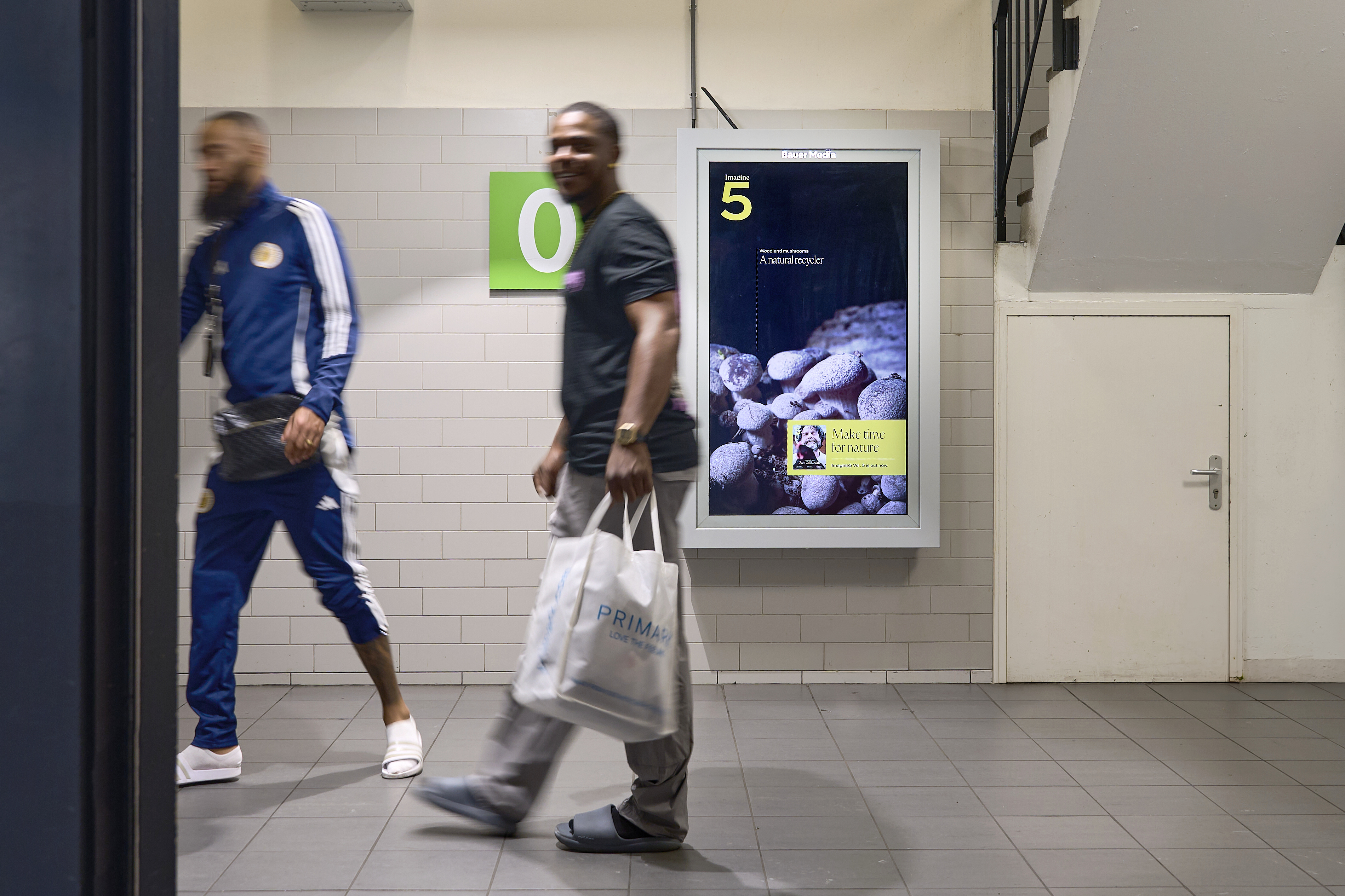 Digitaal scherm in parkeergarage met 2 voorbijgangers