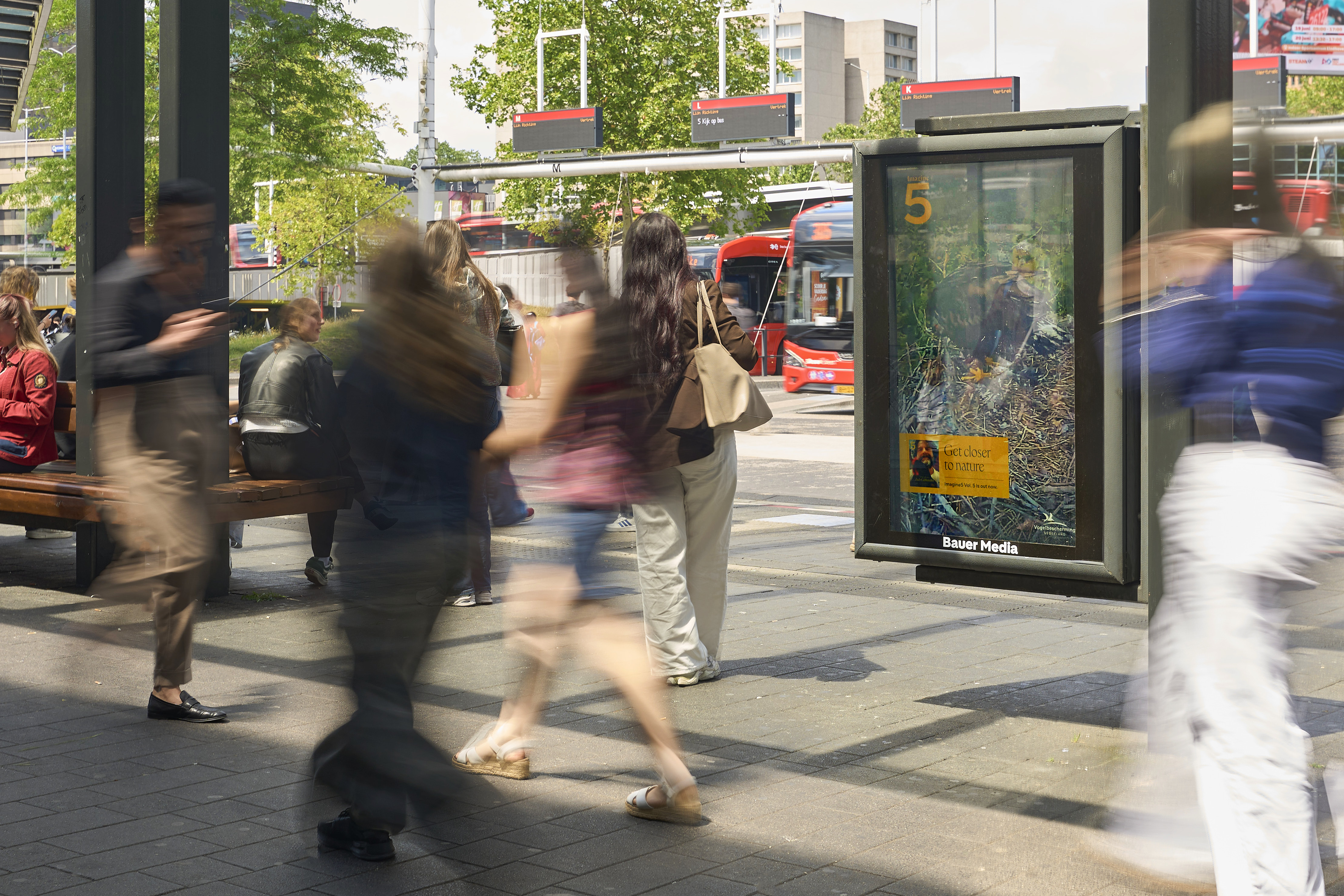 Digitaal scherm in Eindhoven met voorbijgangers en vogel livestrem op scherm