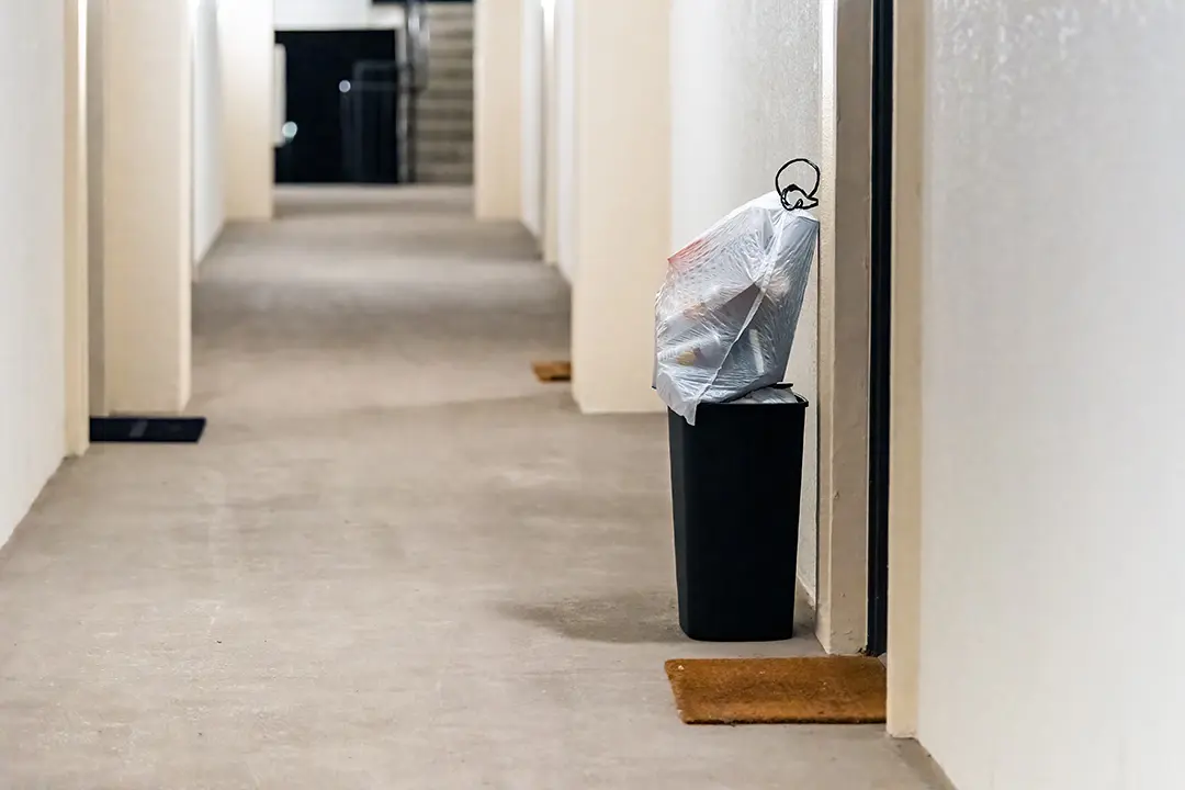 Valet trash service at The Gallery Apartments, with doorstep pickup shown in a clean, well-lit hallway.