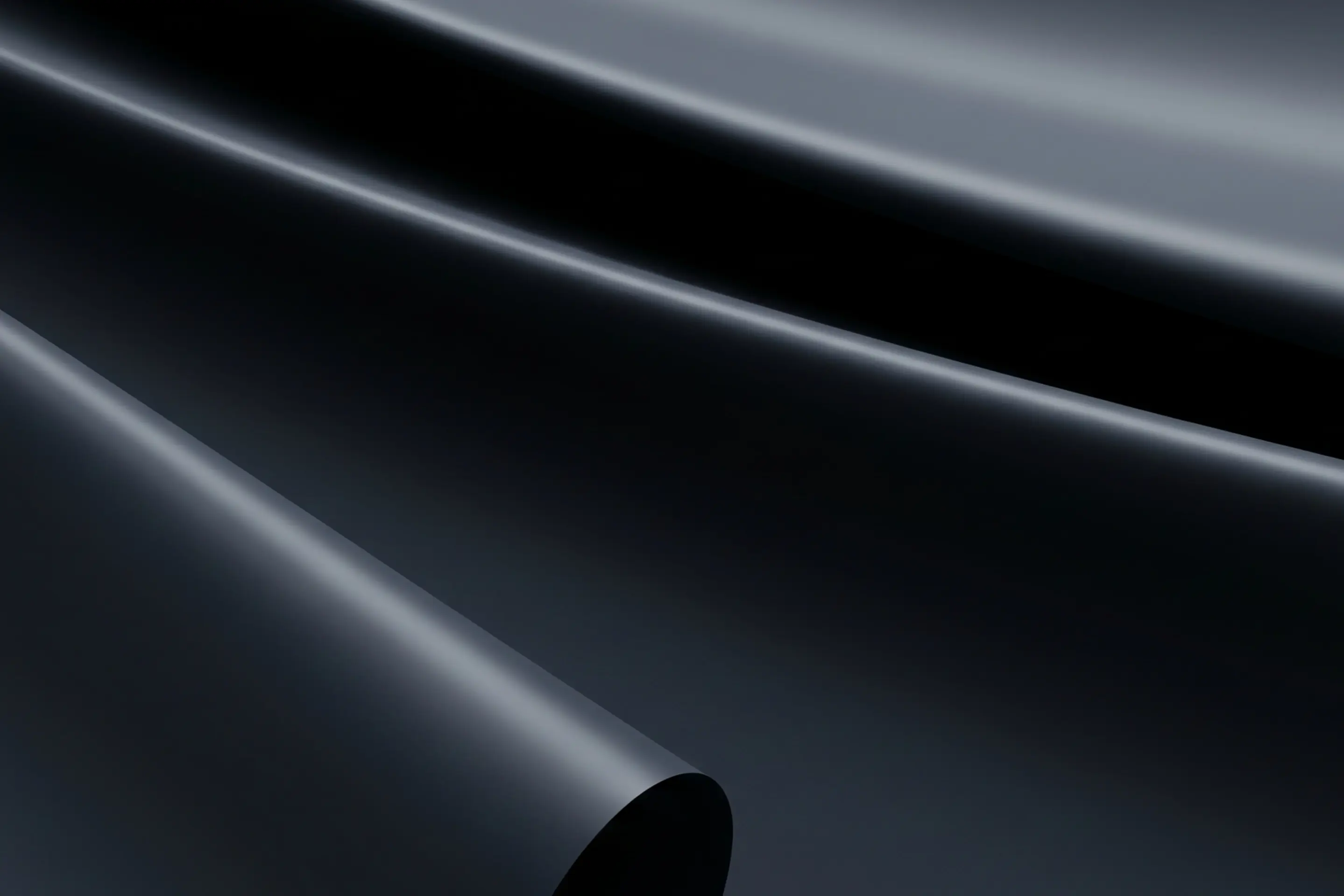 Abstract smooth, flowing black and gray waves resembling fabric or liquid.
