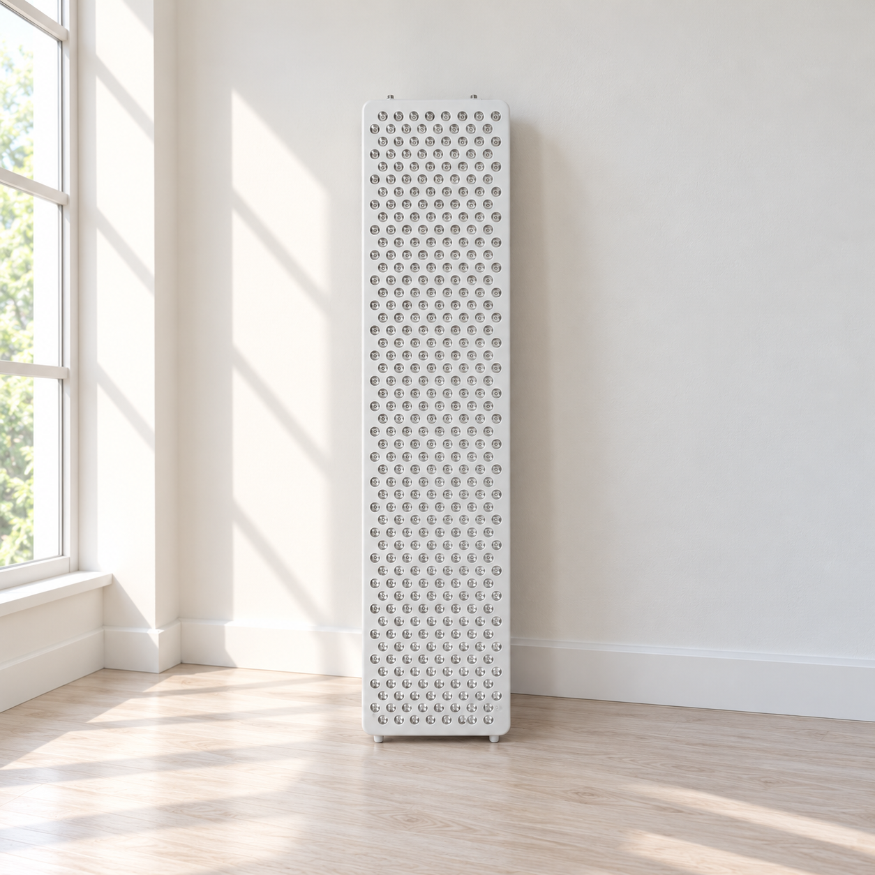 Off-white red light therapy panel standing upright on a light wood floor against an off-white wall