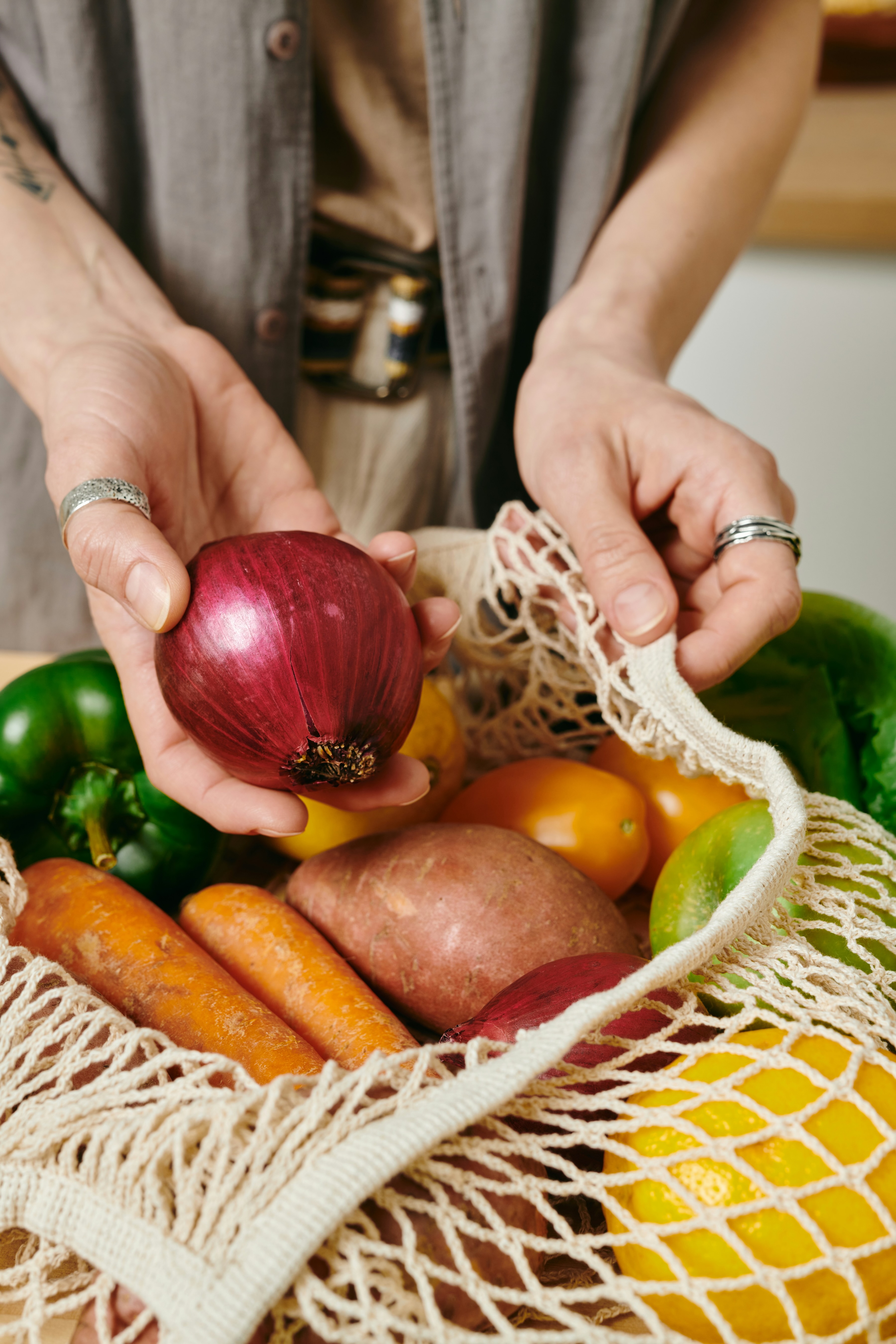 A woven basket of vegetables highlighting a red onion stock image