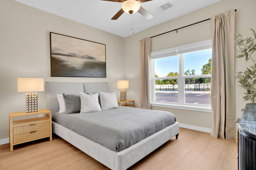 Bedroom with bed, bedside table with lamp, and wall art