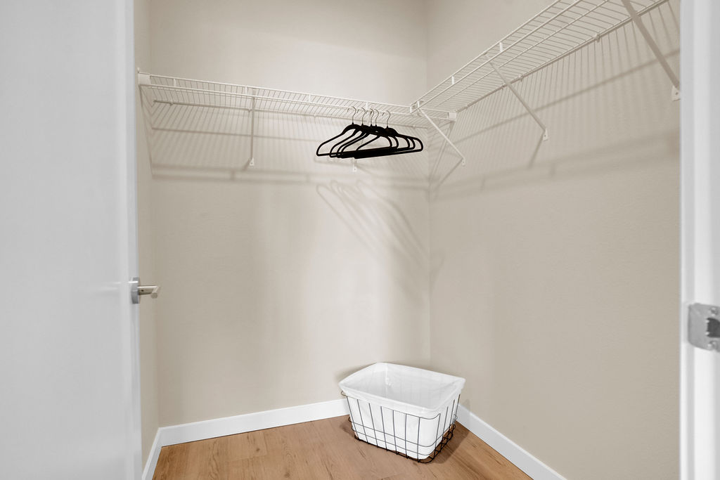 Walk in closet with laundry basket and hangers