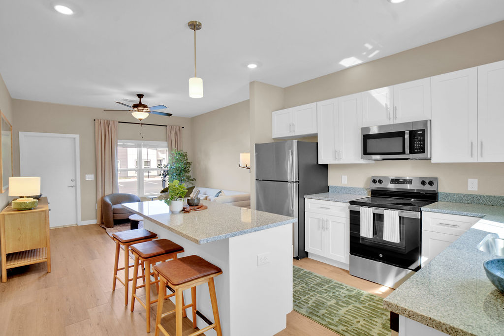 Kitchen with island and chairs, stainless steel appliances and white cabinets
