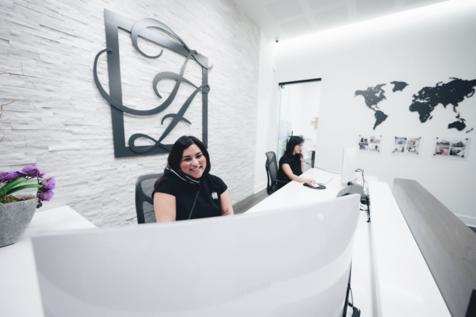 Dental receptionist greeting a patient at the front desk of Fisher & Zitterich Dentistry's modern office.