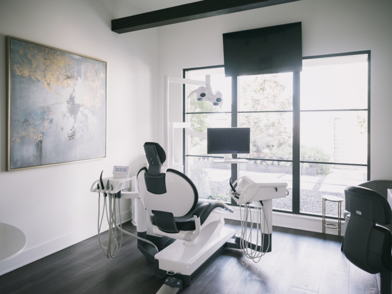 Patient seated in modern dental chair with advanced clinical equipment visible