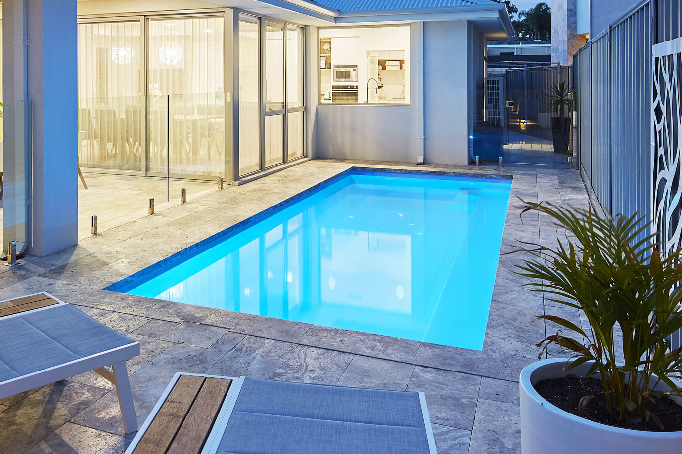 Imperial fibreglass pool at dusk in a paved courtyard