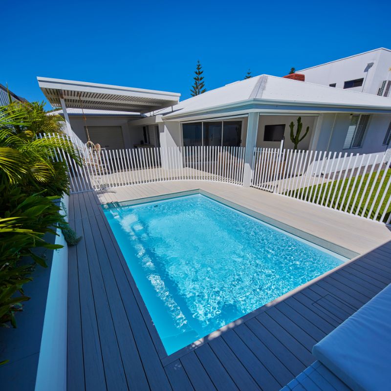 Hamilton Slimline 5.5m pool in Polo White with the family home behind