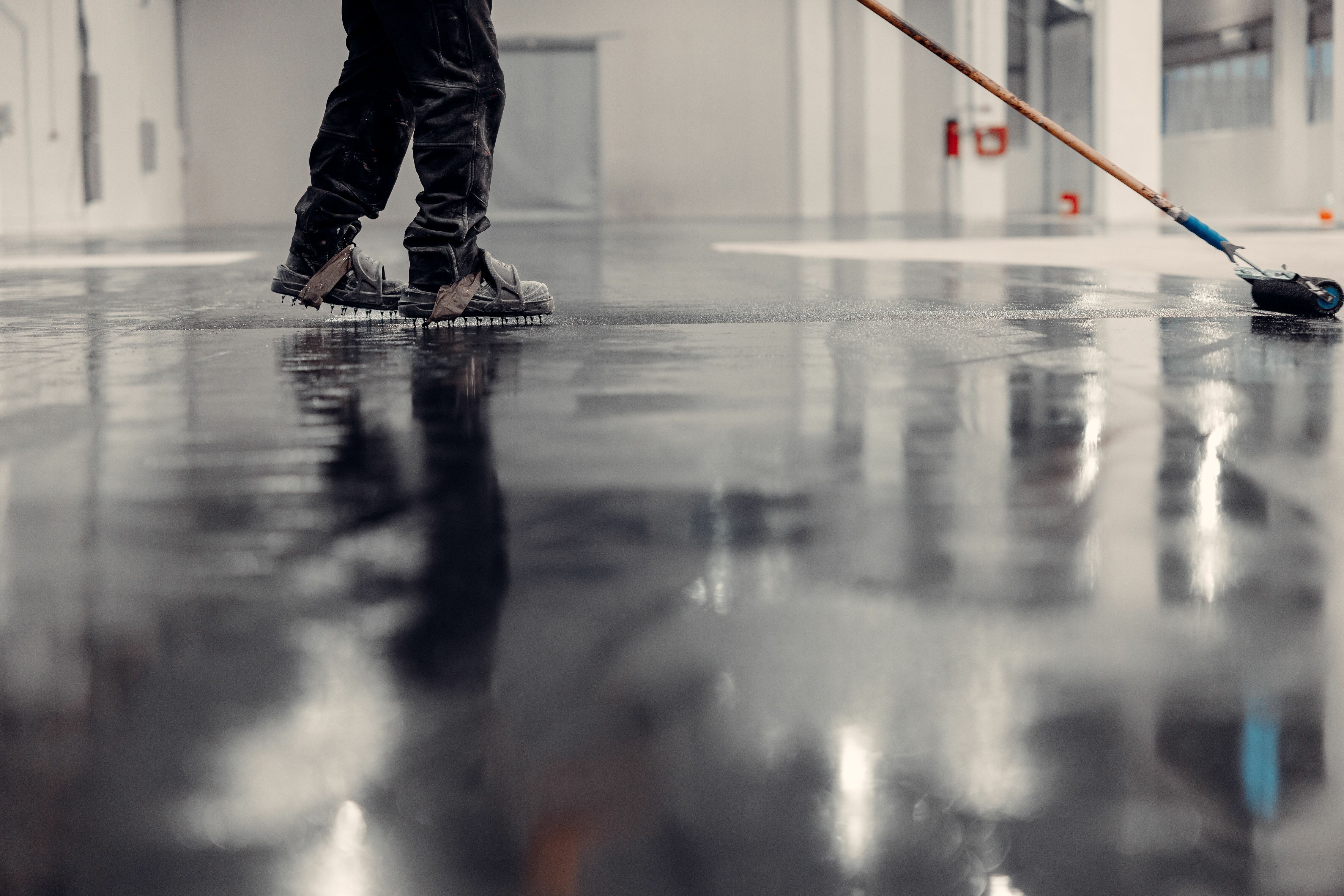 image of epoxy flooring being finished with a person walking in the background