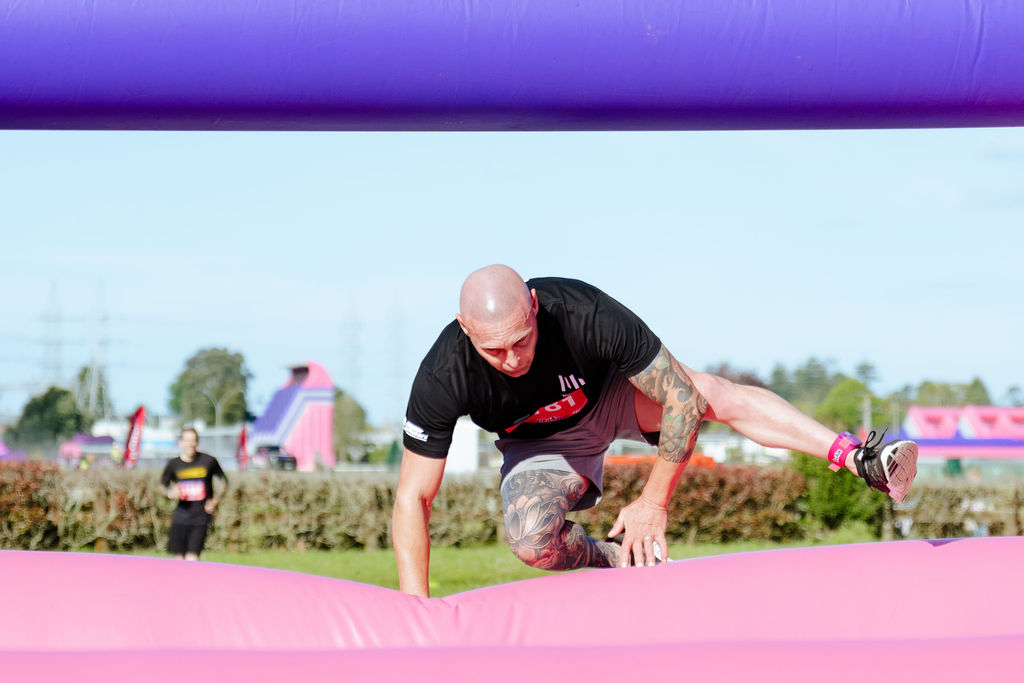 Man crawling under an inflatable bar