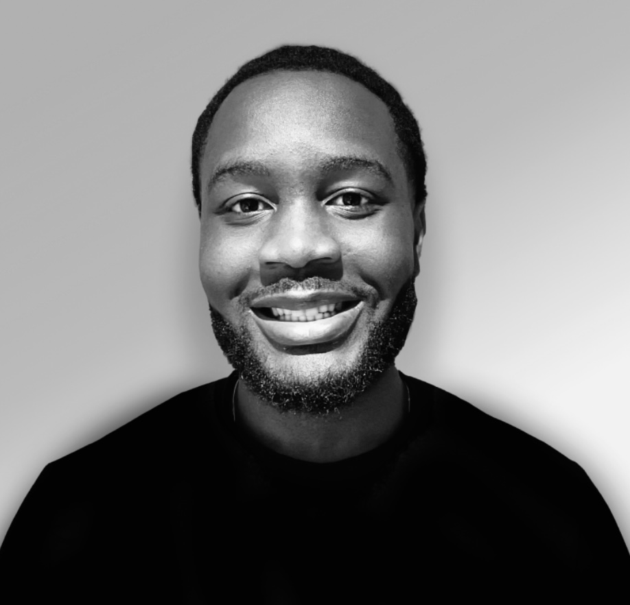 Portrait en noir et blanc d'un homme souriant avec une barbe bien taillée.