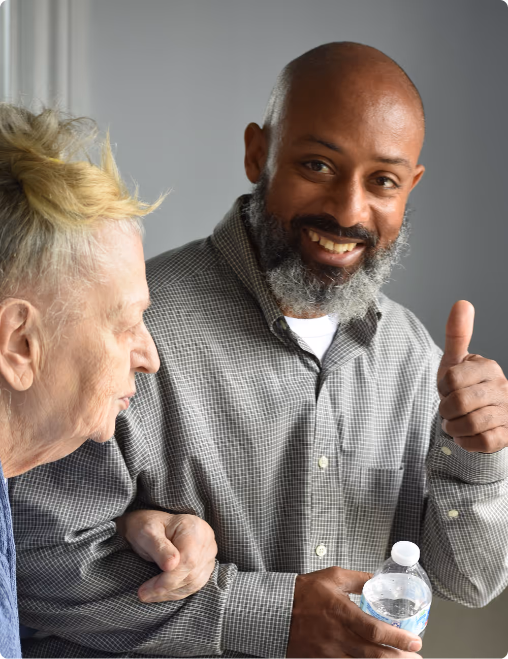 Photo of two church members, one giving a thumbs up gesture