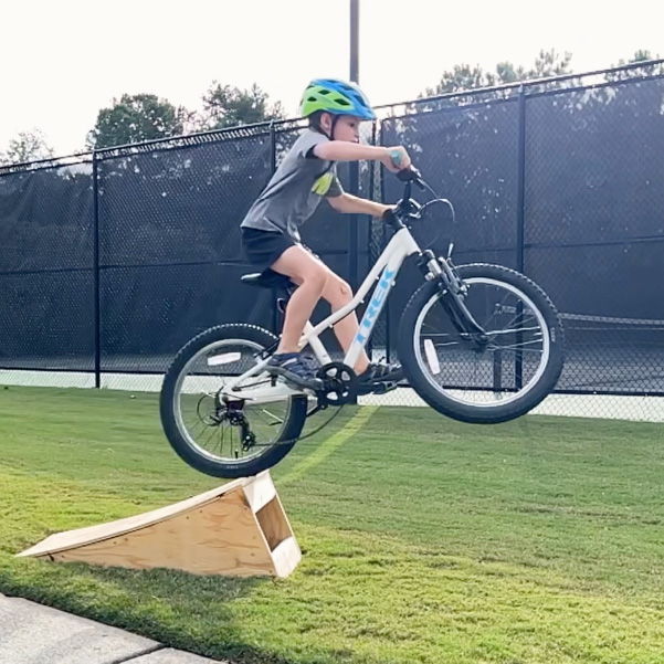 boy jumping bike off of ramp