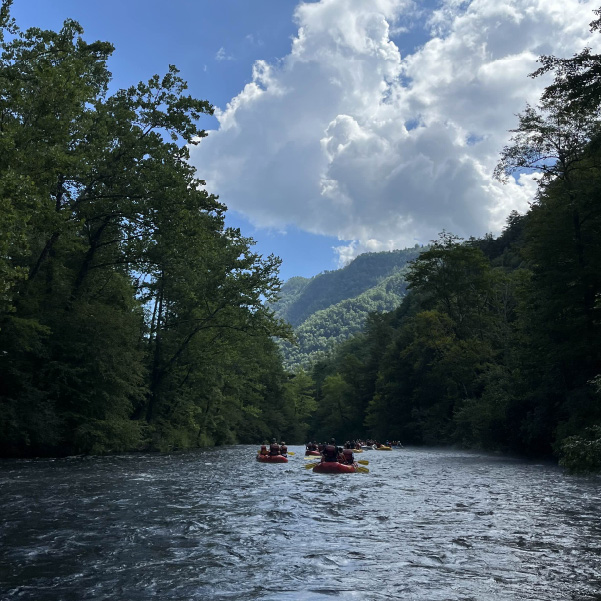 rafting on river with trees and sky