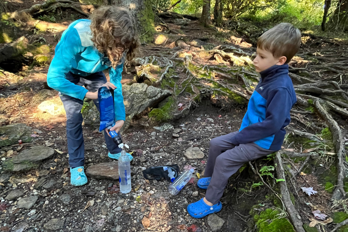 Kids at campsite take turns filtering water