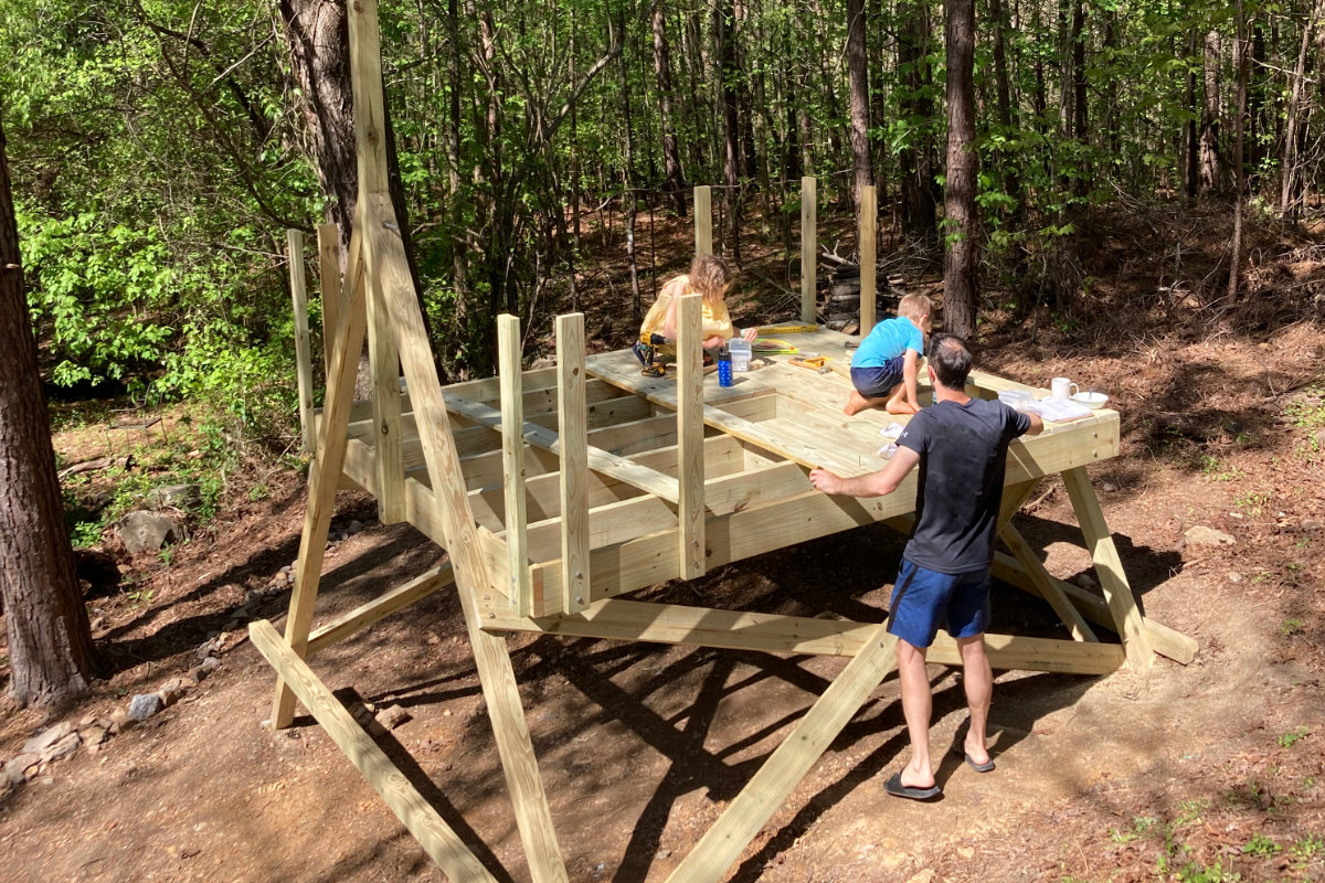 Kids and adult adding treehouse decking