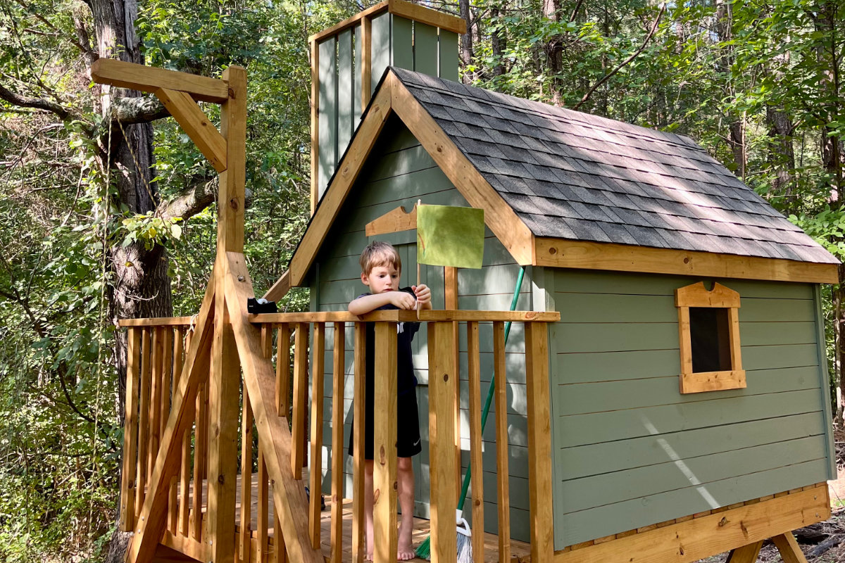 Kid adding flag to treehouse railing