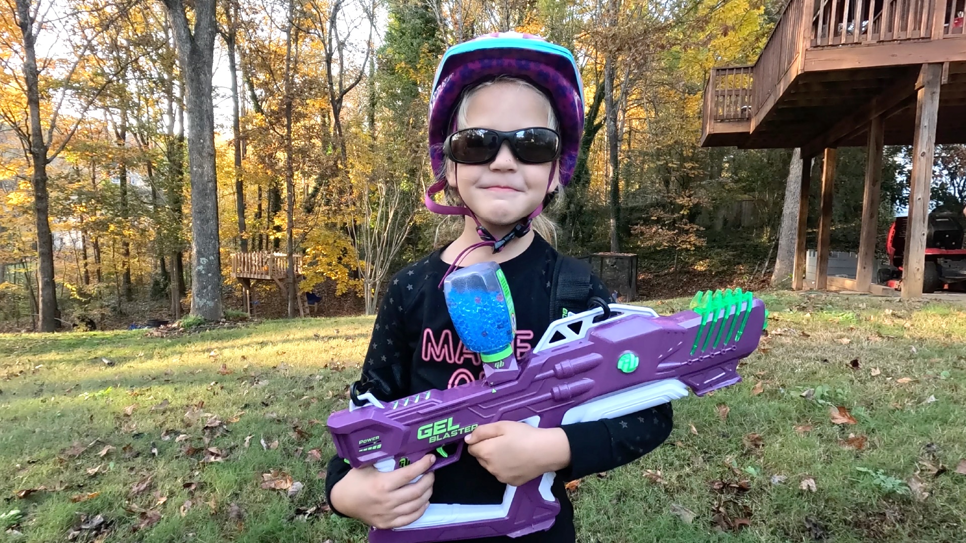 A girl stands with a Gel Blaster
