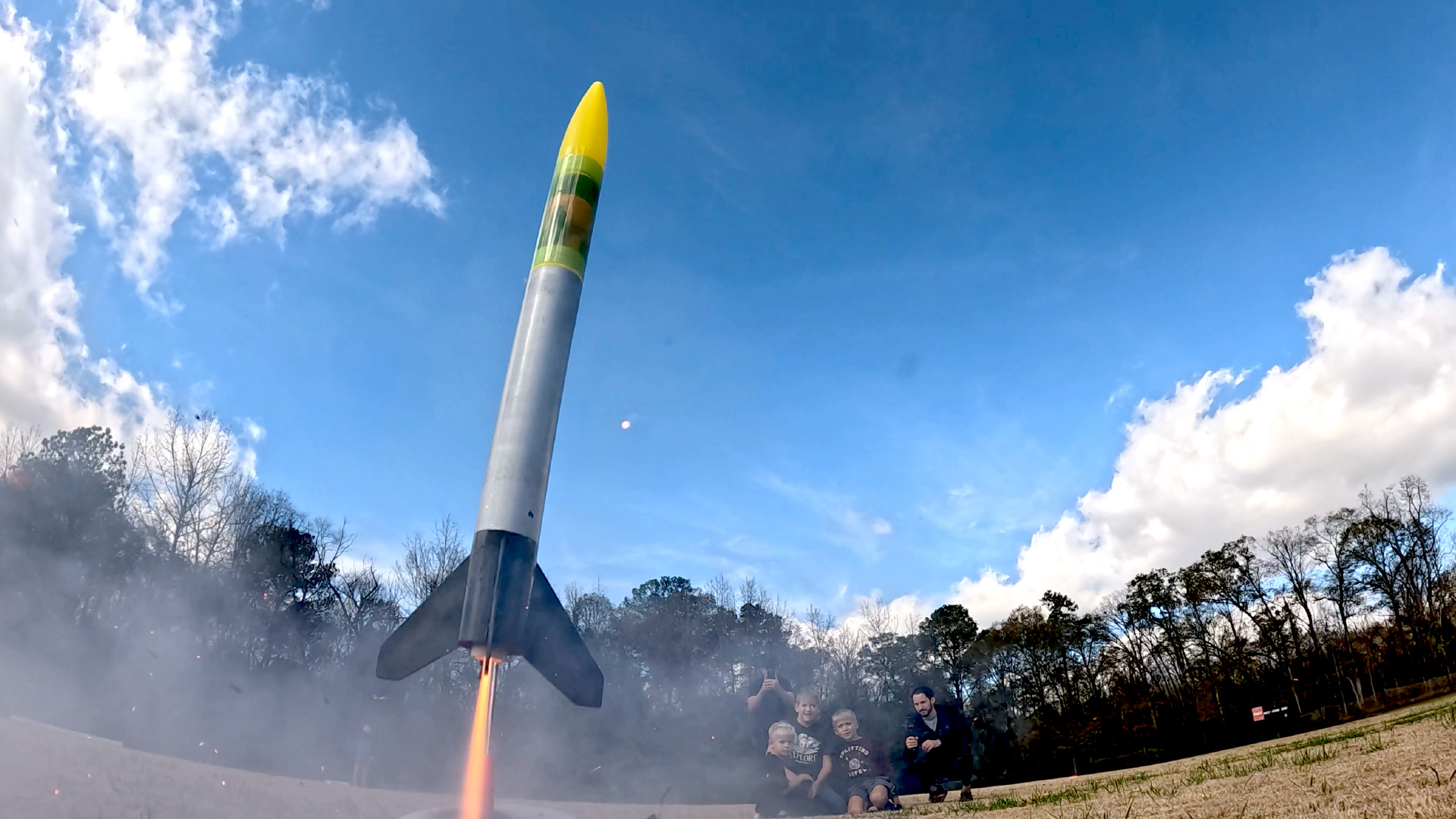 An Estes Green Eggs rocket launches off a launchpad.