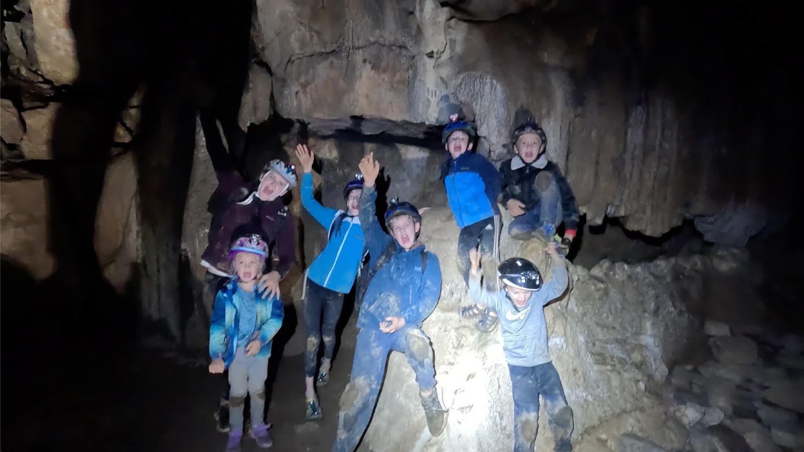 Group of kids cheers in cave