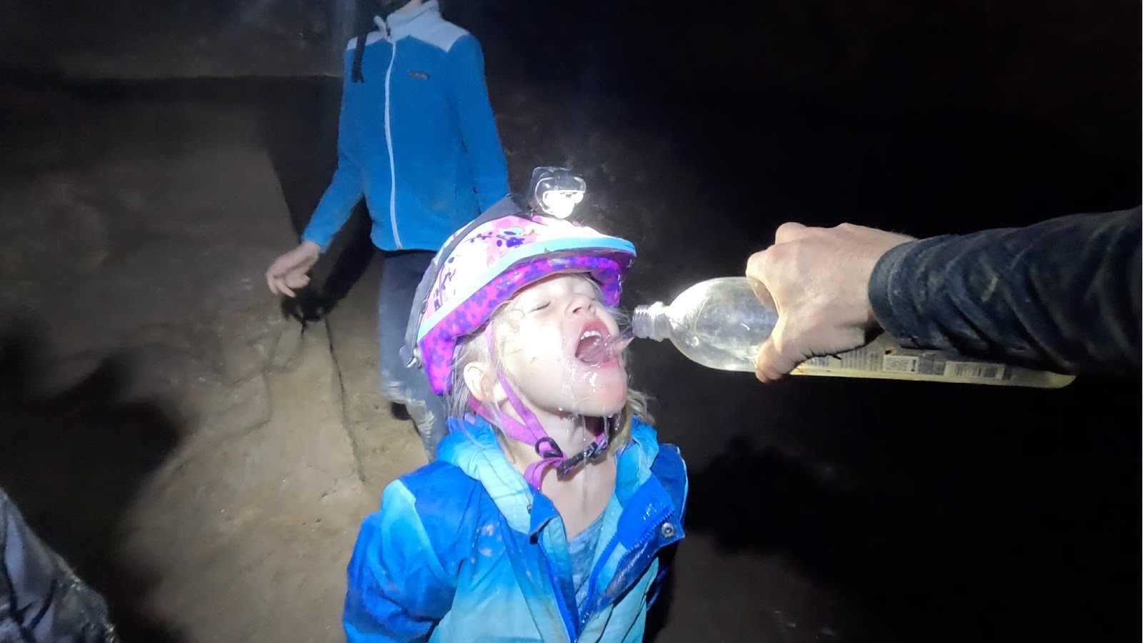 Kid drinking water in cave