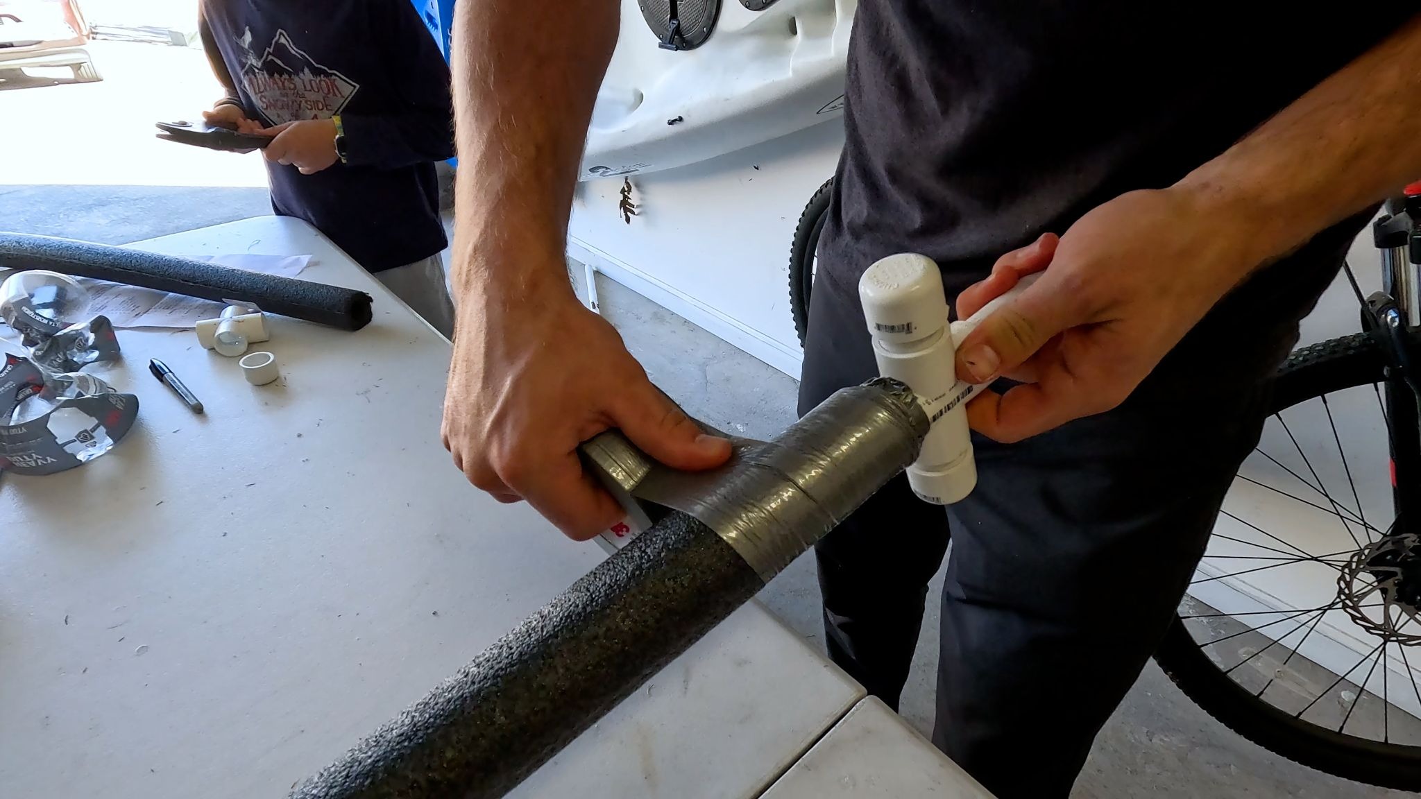 Man wrapping PVC and foam sword in duct tape