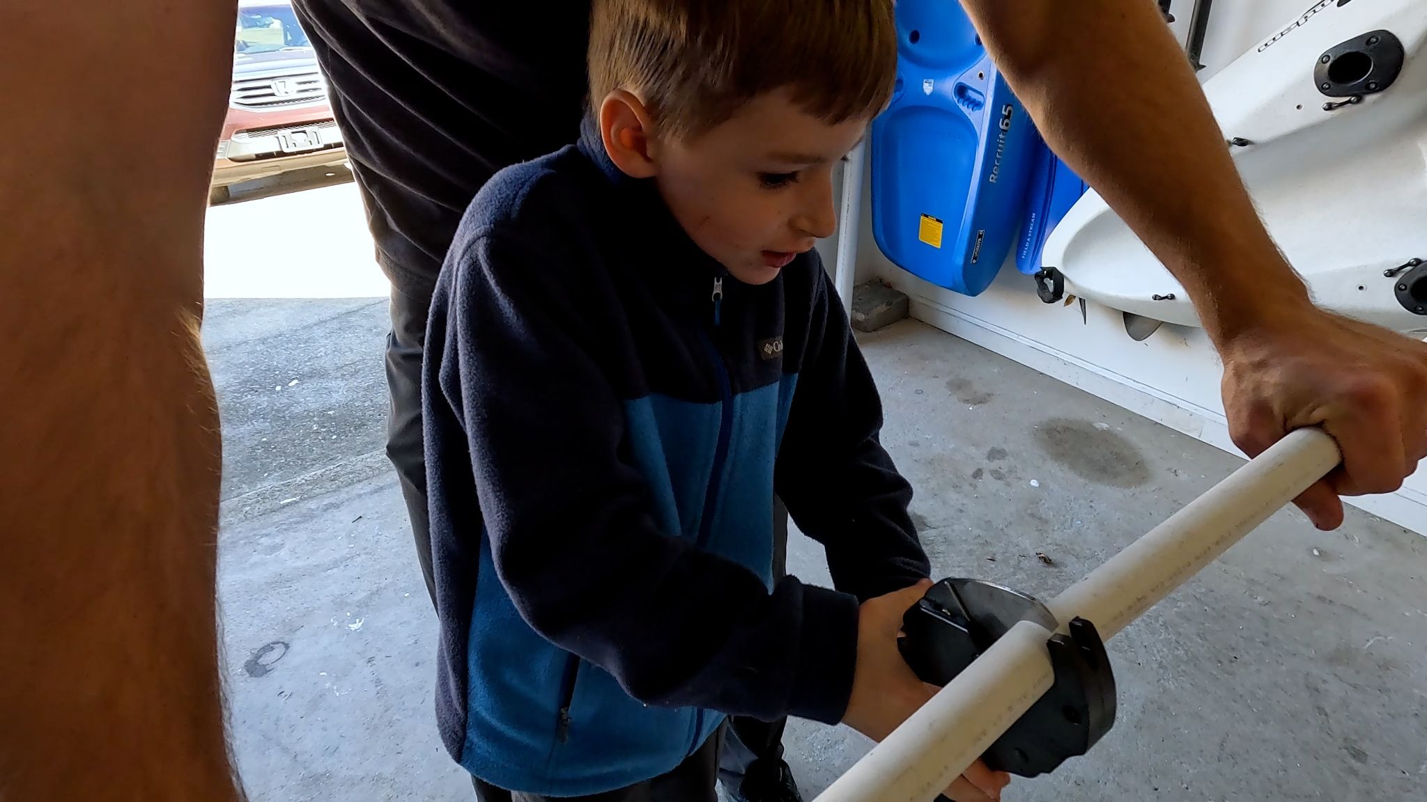 Boy cutting PVC pipe