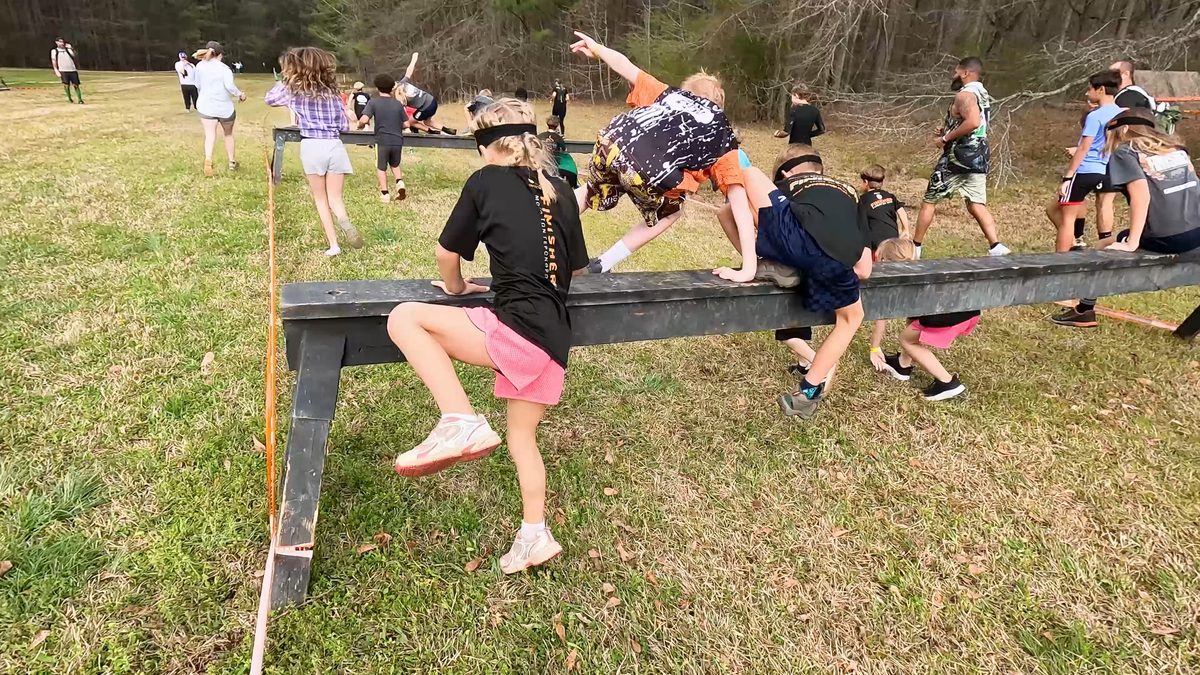Kids climbing over obstacle in race