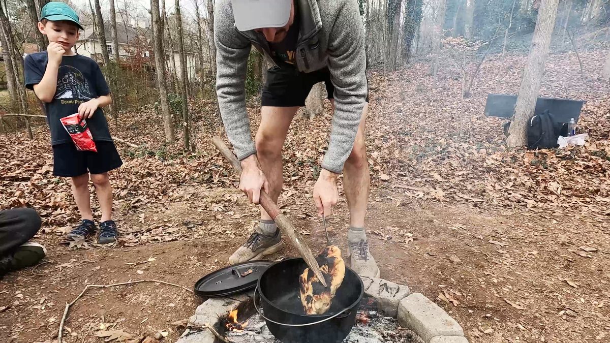 Flipping the campfire bread in the pot.